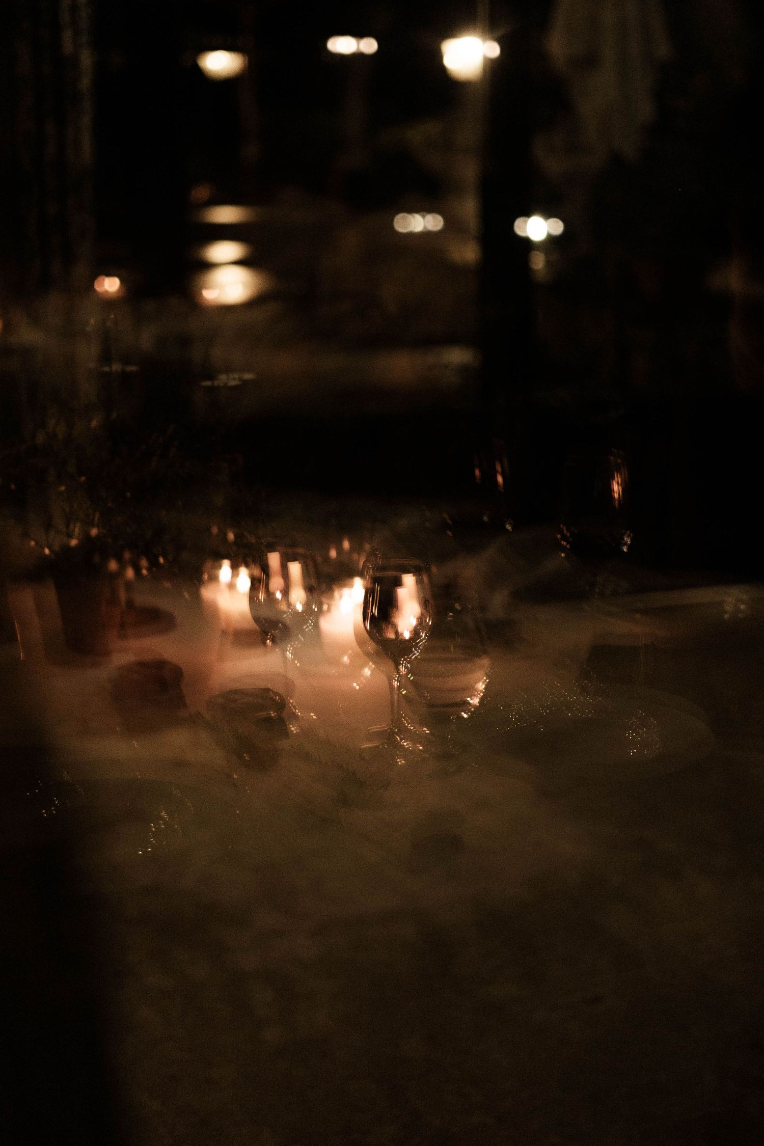 Blurry nighttime scene with glowing lights and silhouettes creating an atmospheric, moody ambiance.