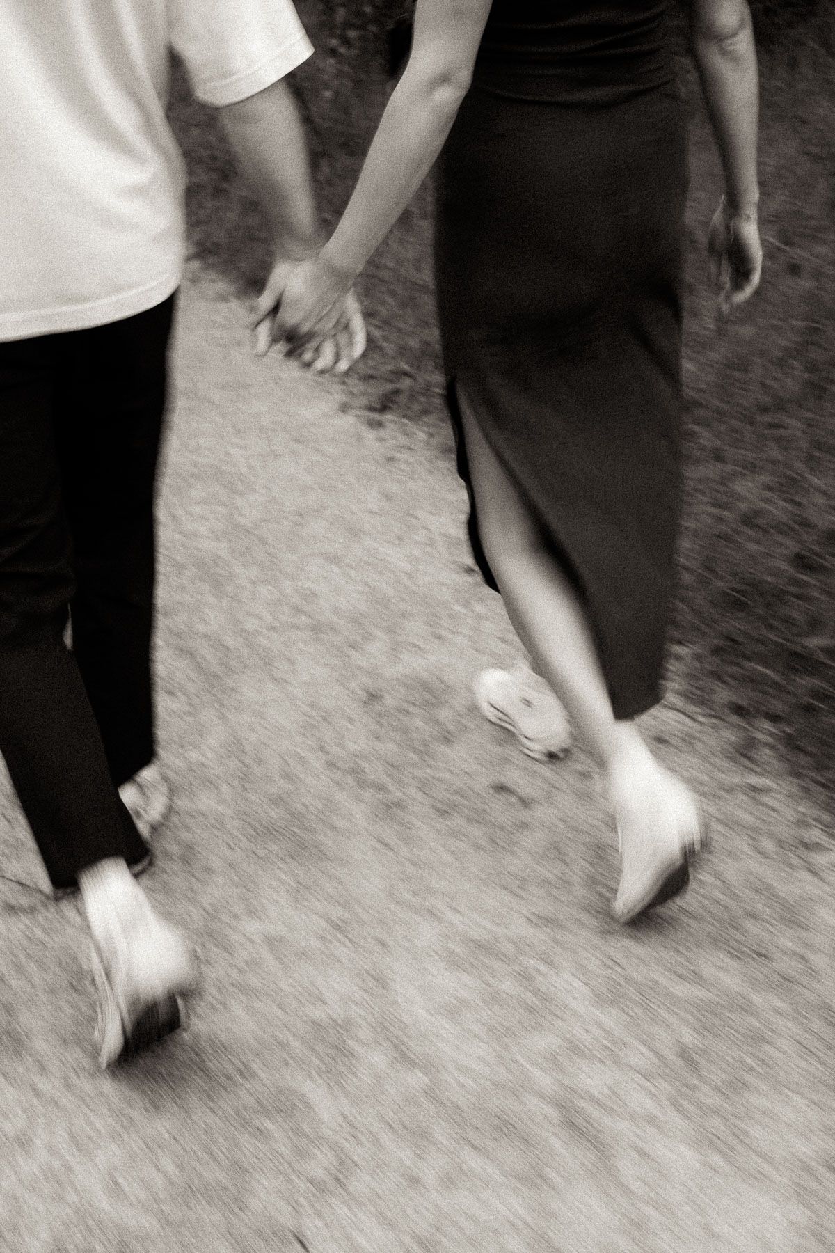 Black and white image showing feet of dancers performing ballroom dance steps on a carpeted floor.