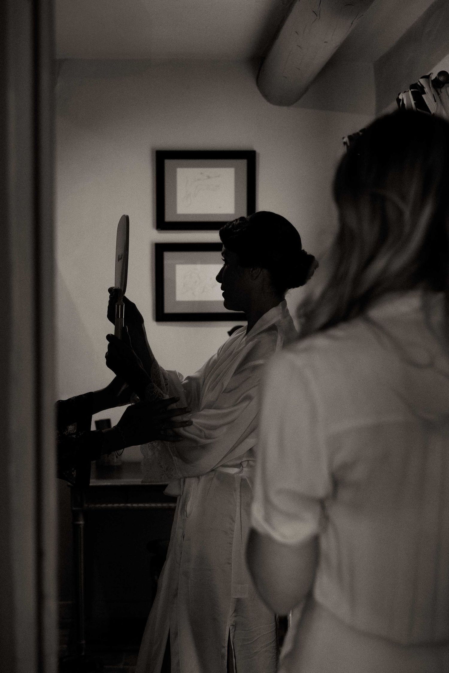 Medical professionals in white coats examine diagnostic images on wall-mounted displays in a dimly lit hospital room.