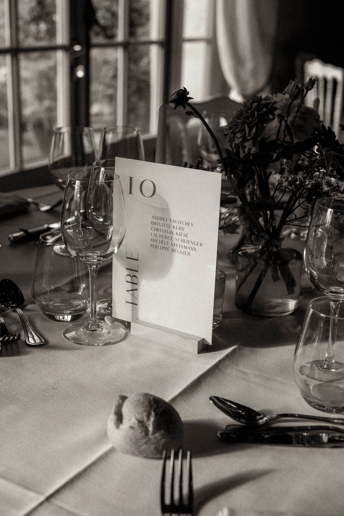 Elegant black and white table setting with wine glasses and place cards in a formal dining arrangement.