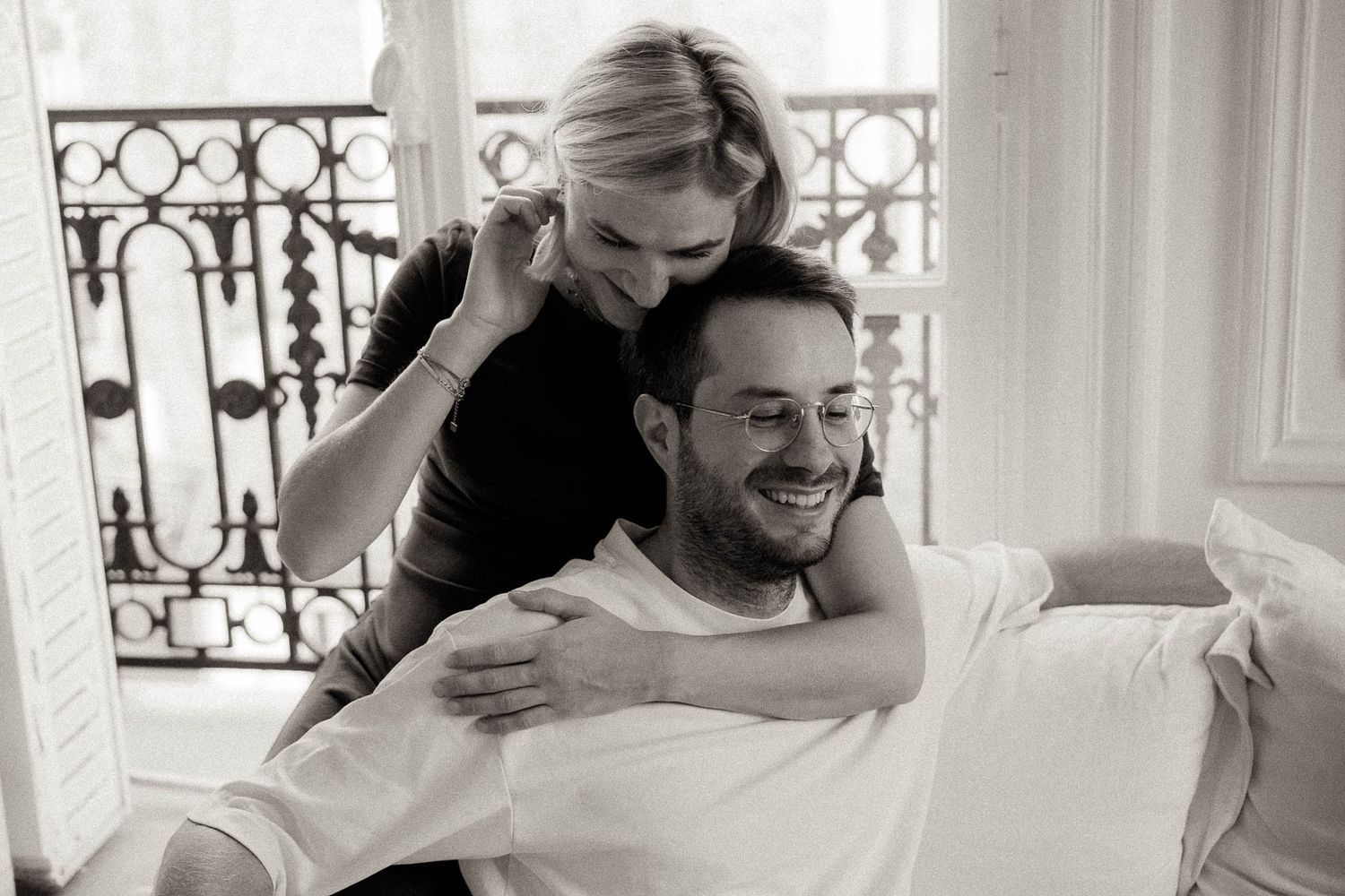 A series of candid black and white photos showing tender moments between couples in a bright interior space.