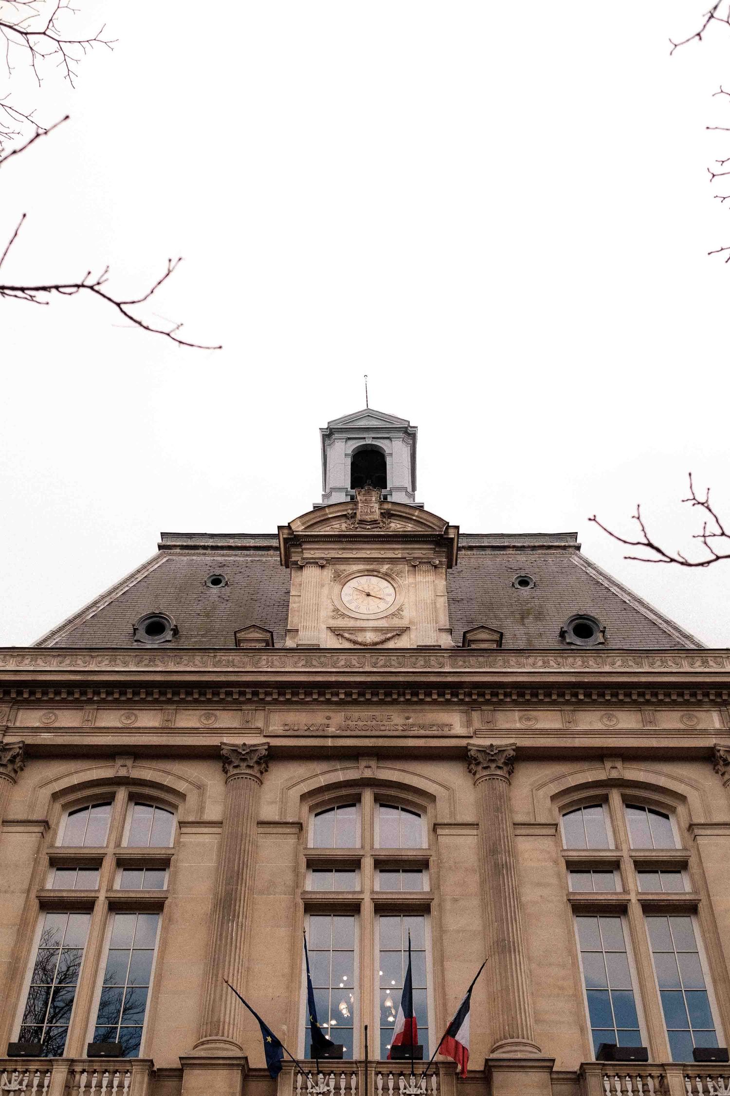Historic stone building facade with ornate architectural details, large windows, and classical European style roofline.