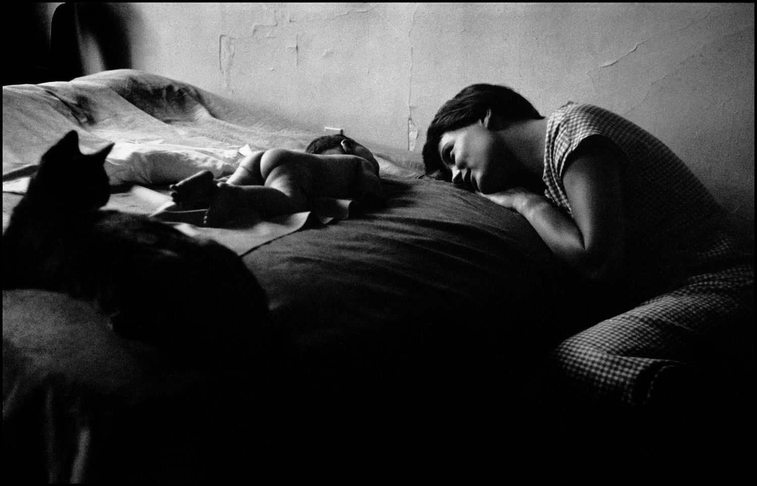 A series of black and white photographs showing rumpled bedding and pillows in dim lighting.