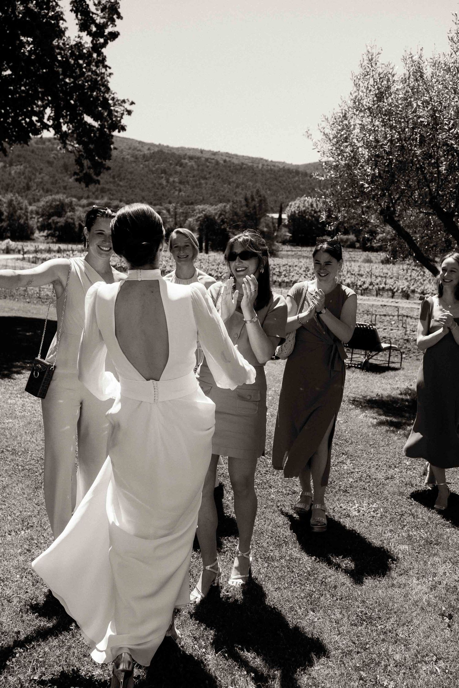 A sequence of black and white photos showing people dancing in a line at an outdoor celebration.