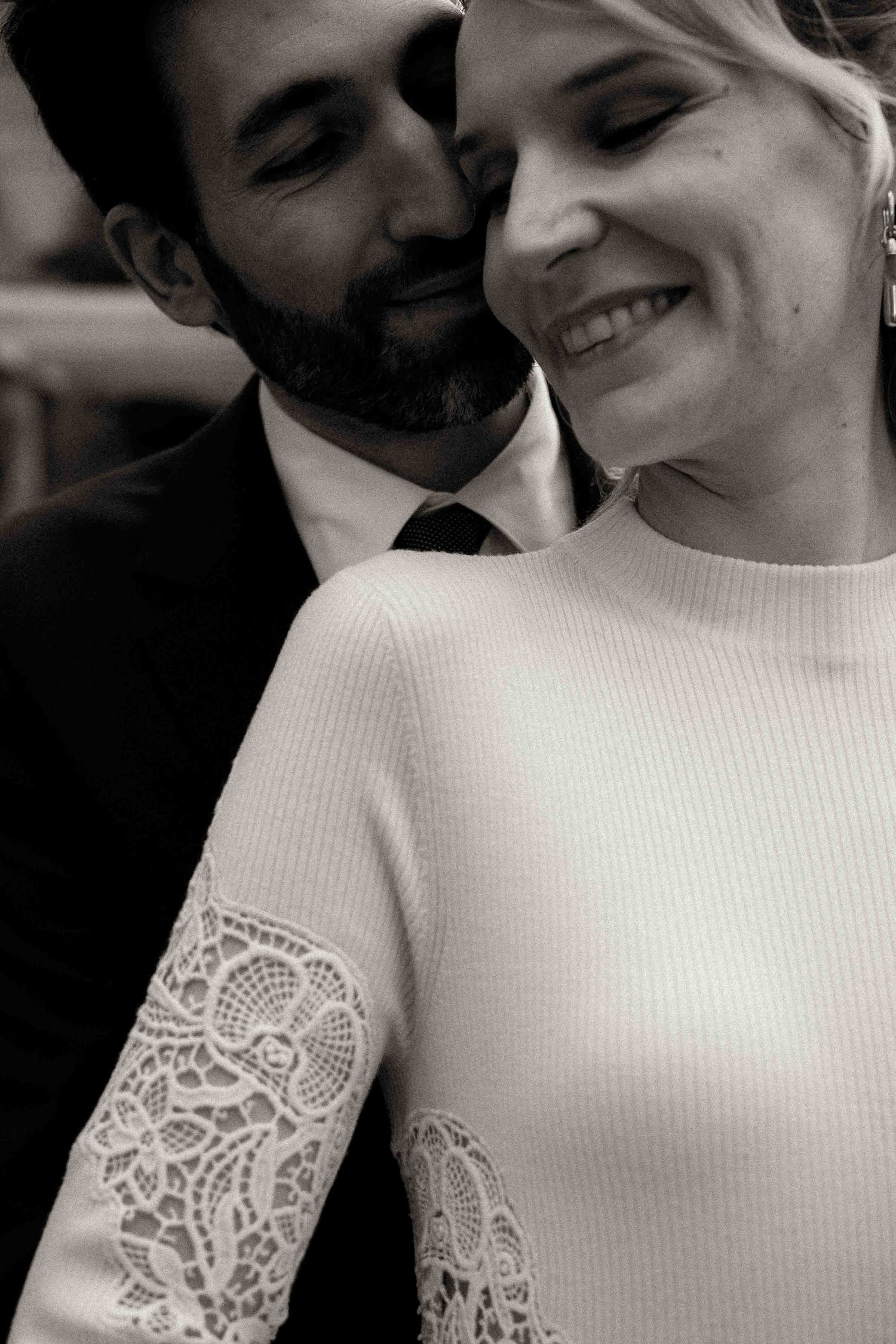 Close-up details of a white wedding dress with delicate lace embellishments and textured fabric.