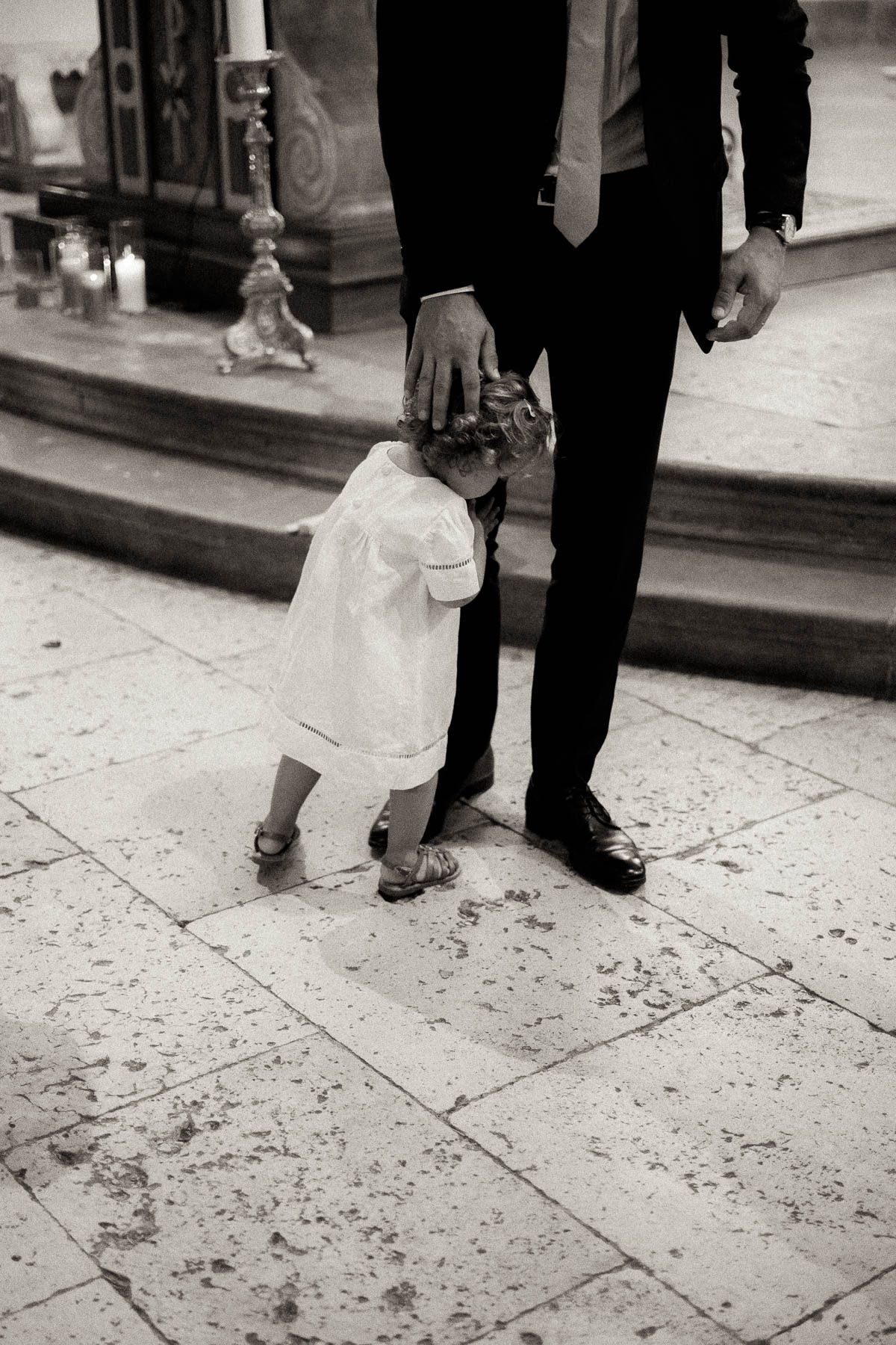 A series of black and white photos showing adult and child feet walking on a stone sidewalk.