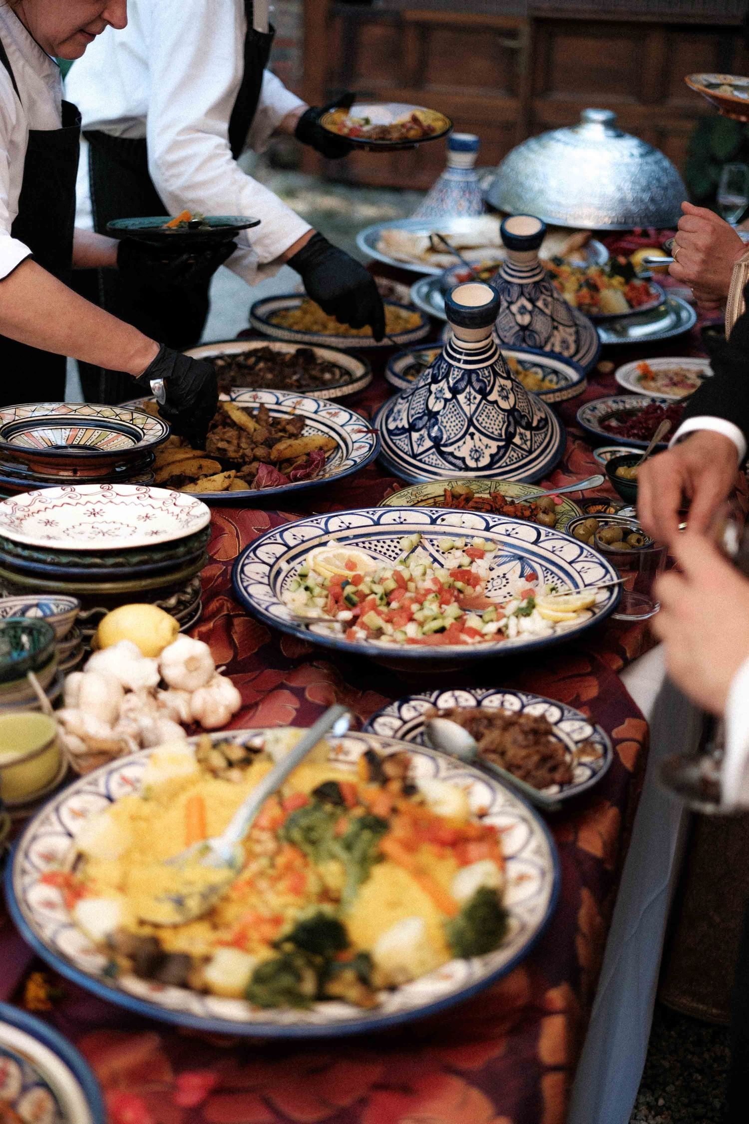 Colorful plates of Mediterranean cuisine served on decorative blue and white dishes at a restaurant table.