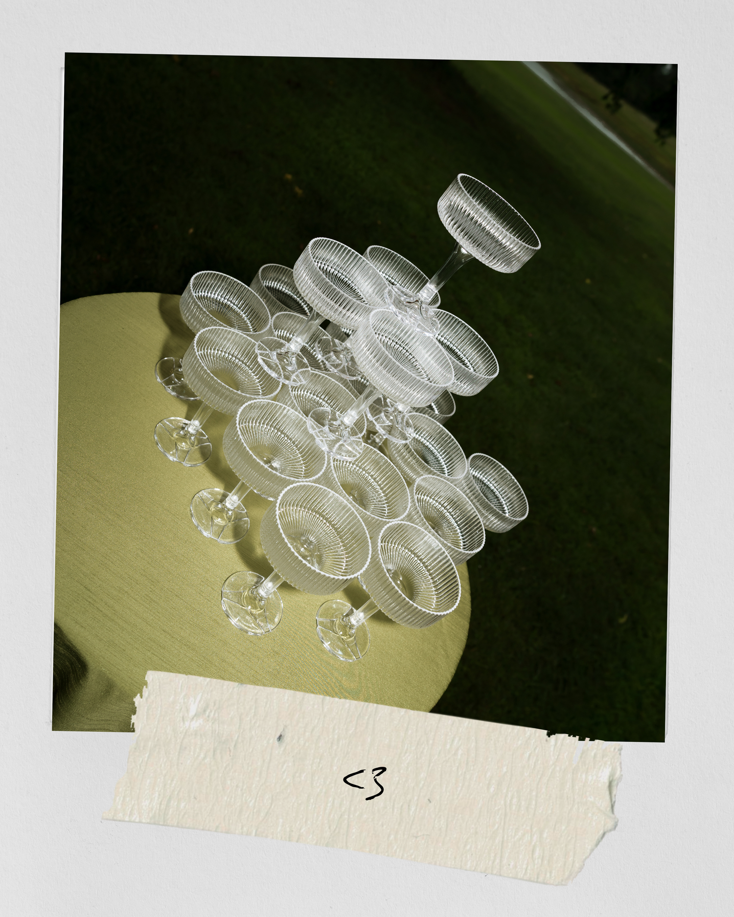 Aerial view of crystal champagne glasses arranged on a round table with heart symbol.