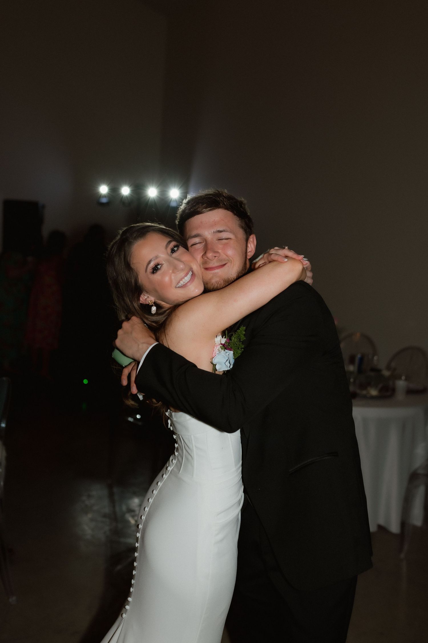 Bride and groom share a tender embrace on the dance floor during their wedding reception.
