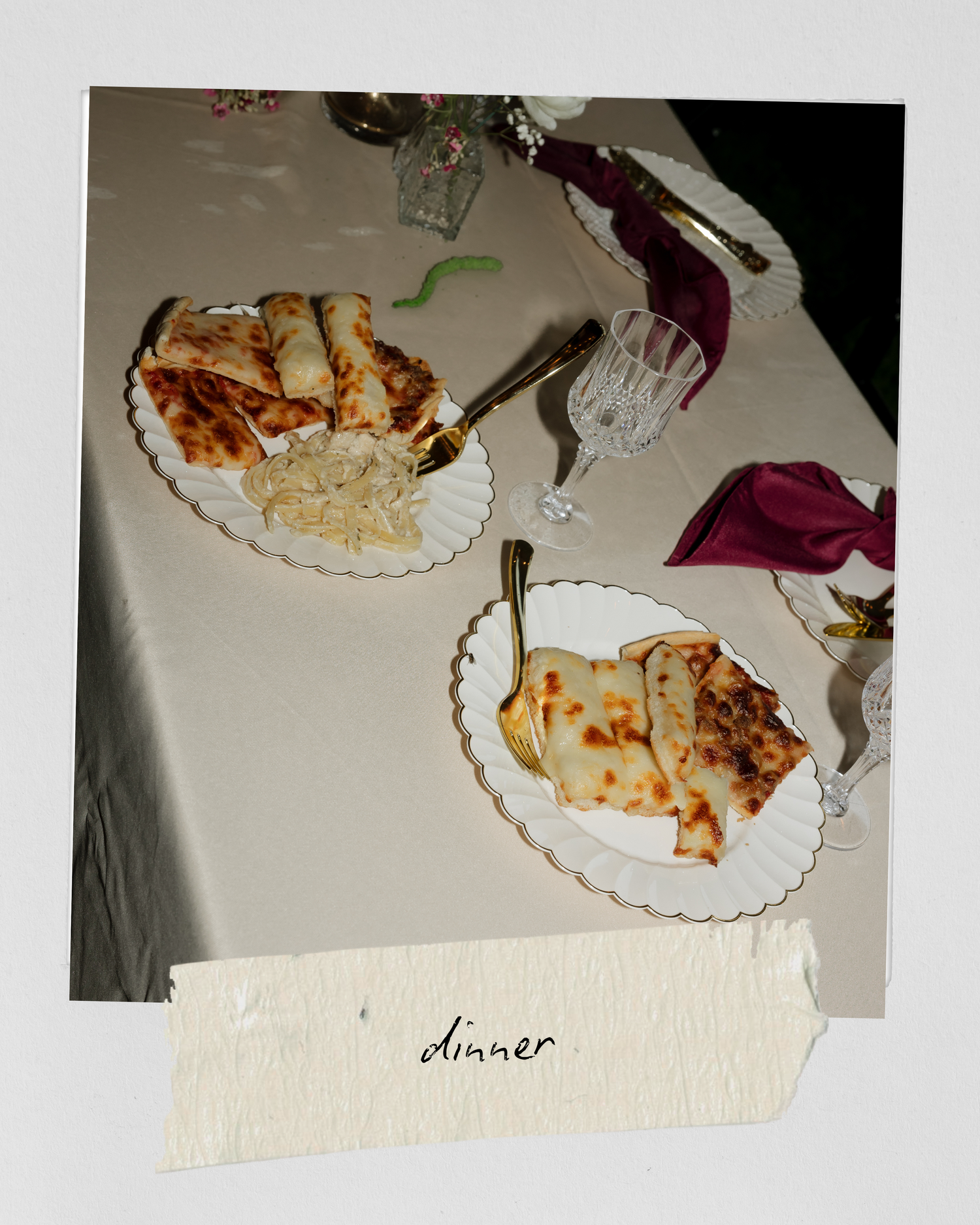 Overhead view of elegant wedding dinner plates with food on white tablecloth labeled dinner.