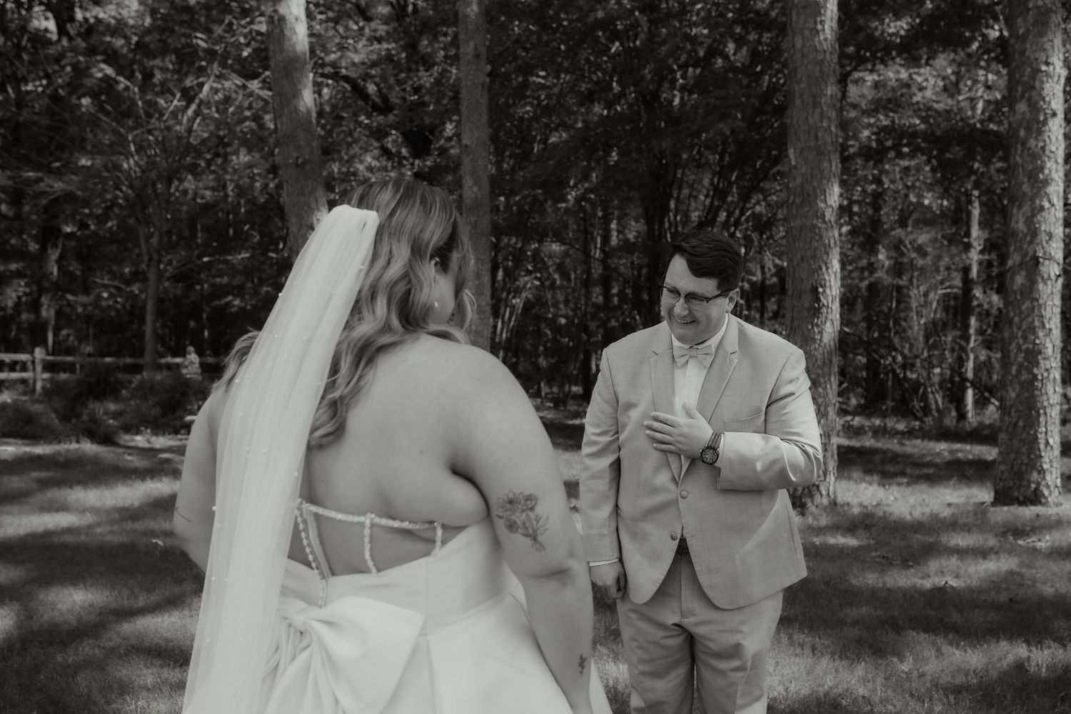 Black and white photo of a groom seeing his bride for the first time during a wedding first look.