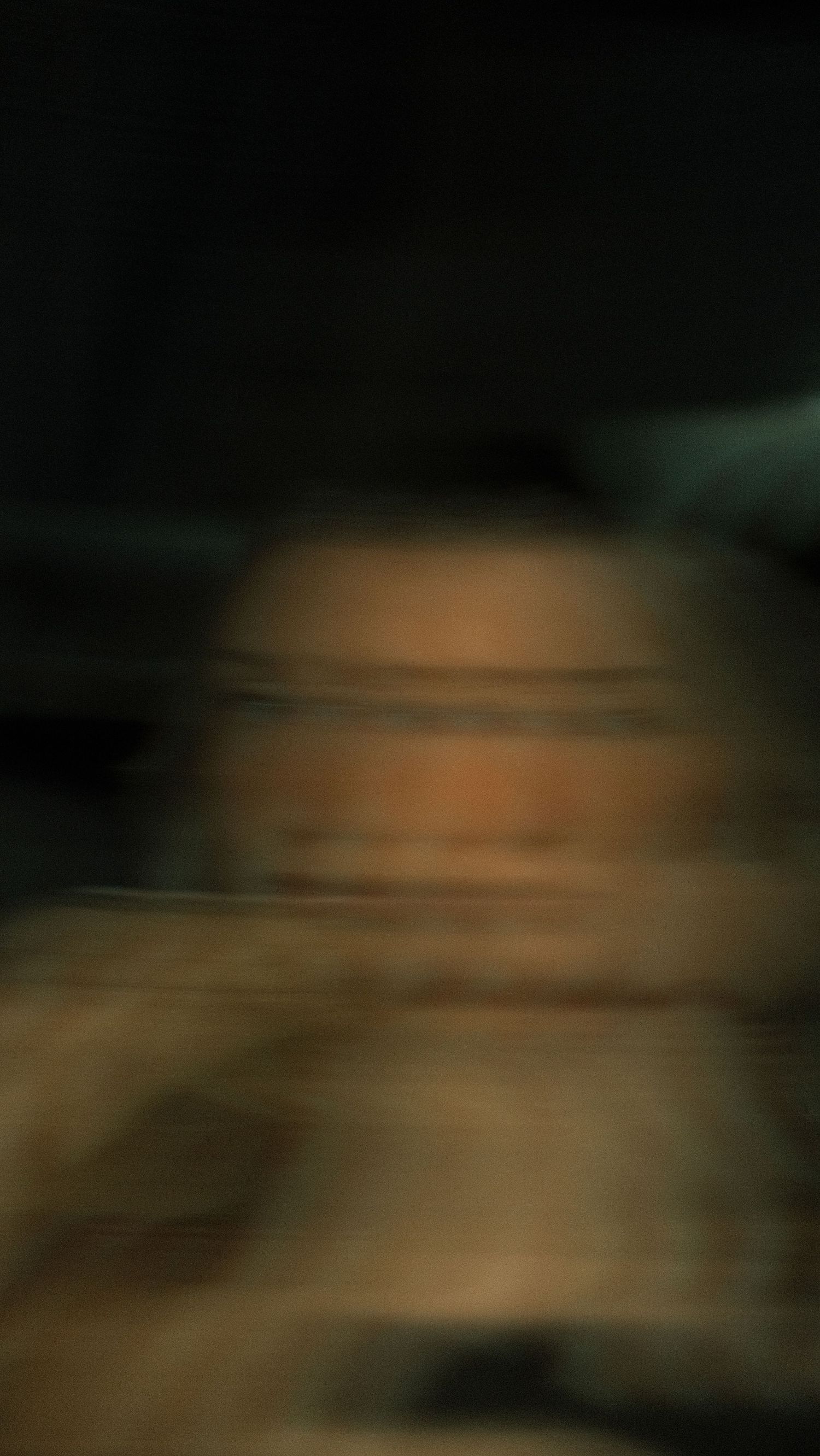 Blurry dark low light portrait photo with motion blur effect, abstract face photography.