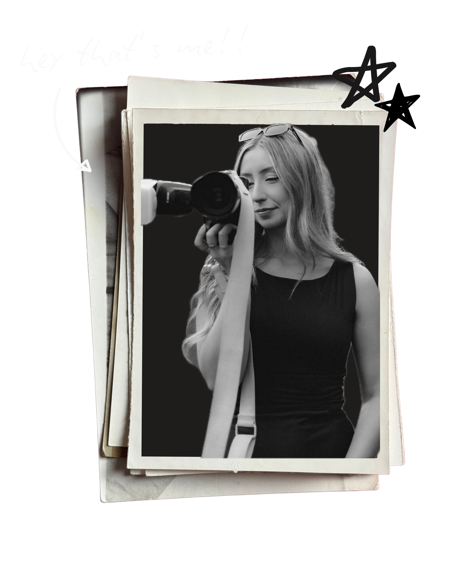 Black and white portrait of blonde female photographer holding camera up to shoot.