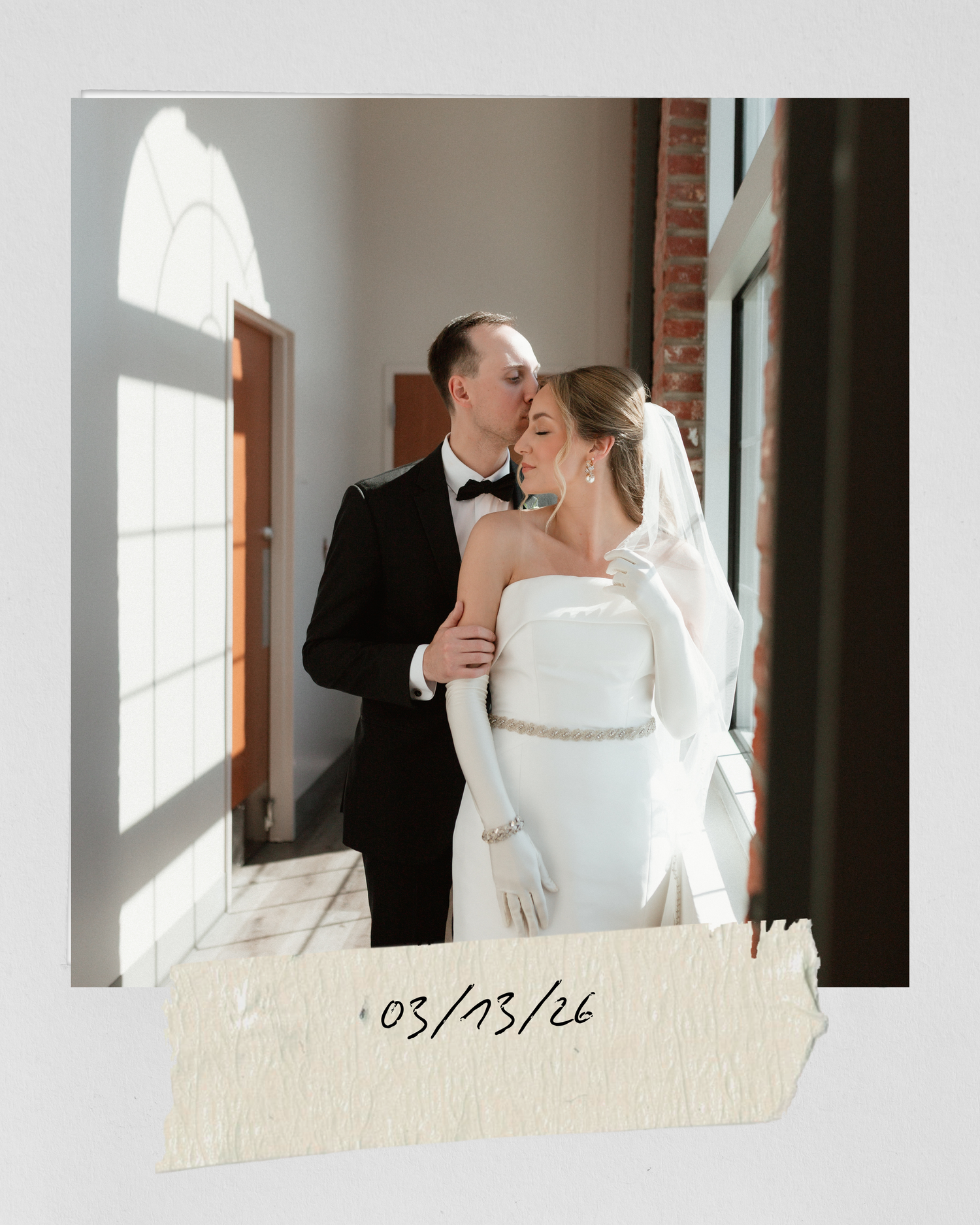Bride and groom share a tender kiss in a sunlit venue, photo styled as a polaroid dated 03/13/26.