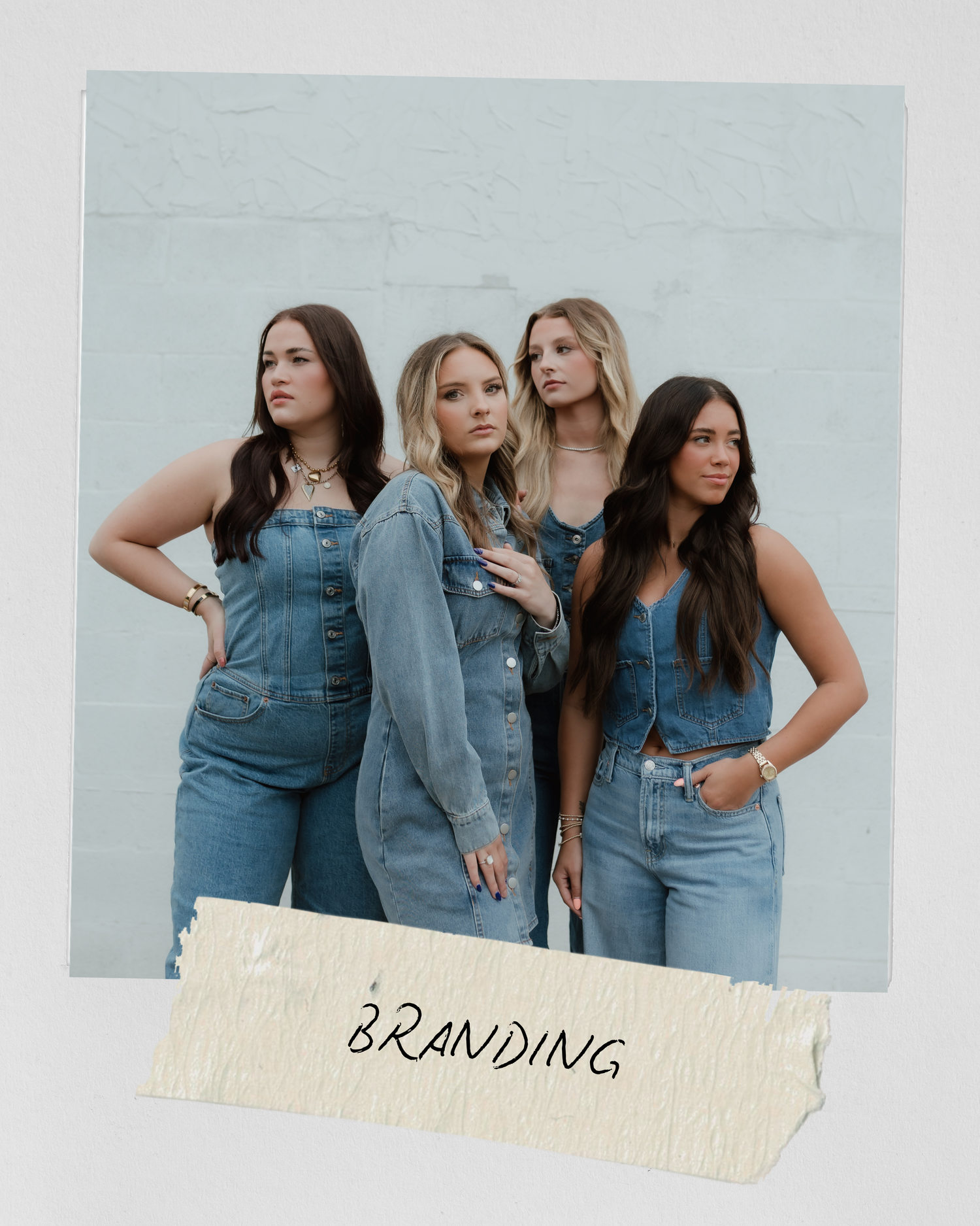 Four women in denim outfits pose together for a stylish branding photoshoot against a light blue wall.