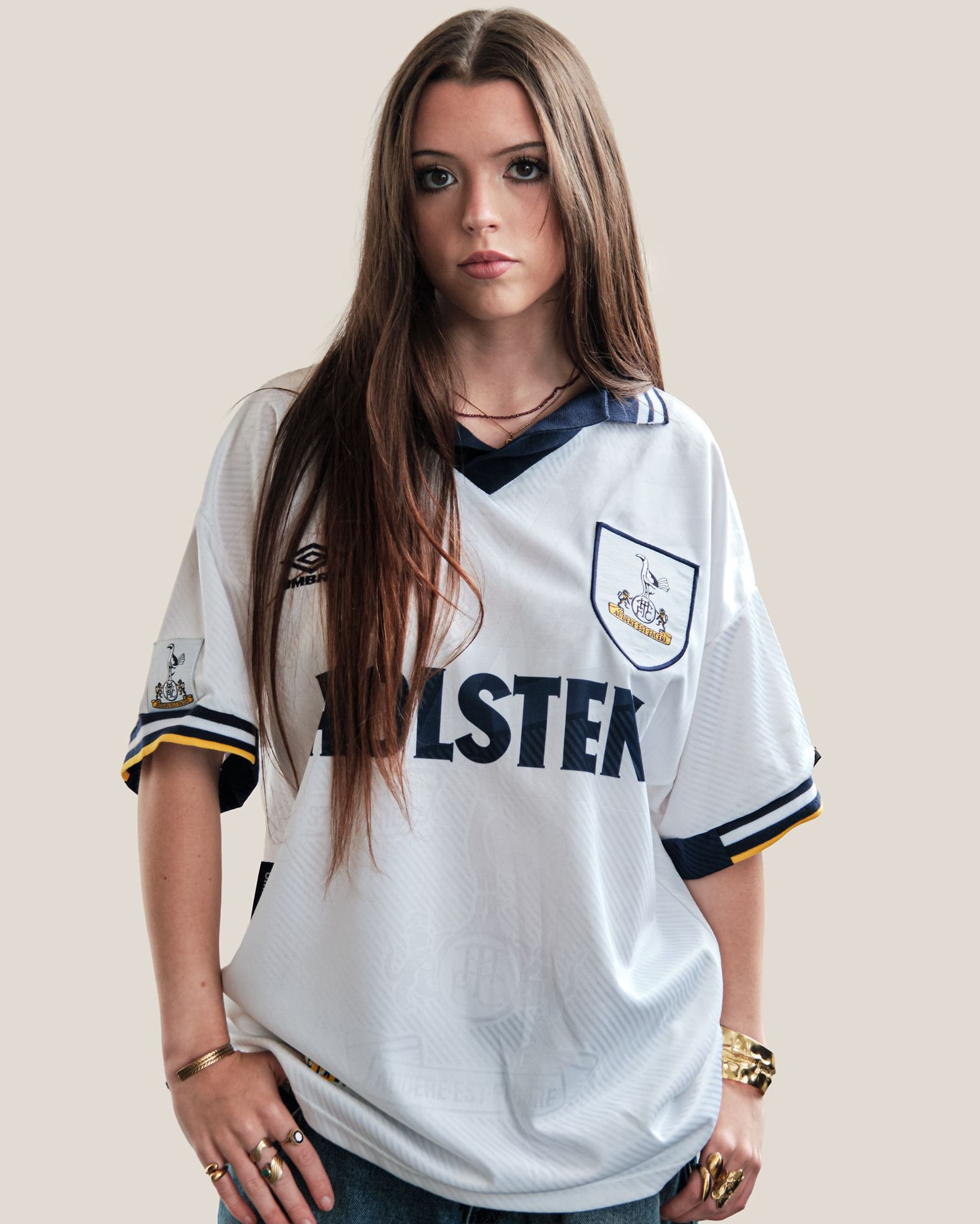 Person modeling a white sports jersey with navy trim and text.