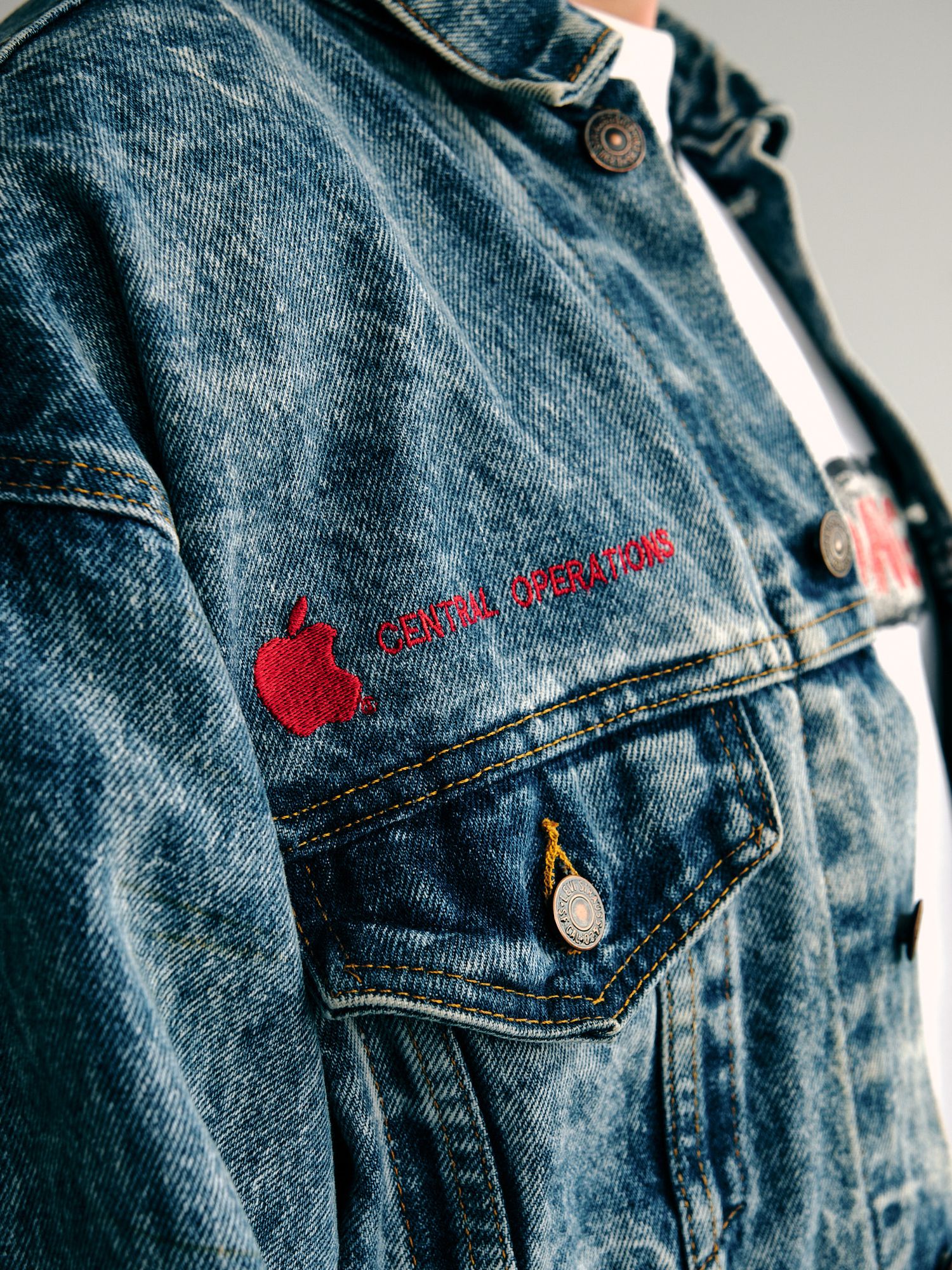Detail shots of vintage denim jacket showing red embroidered text and metal buttons.