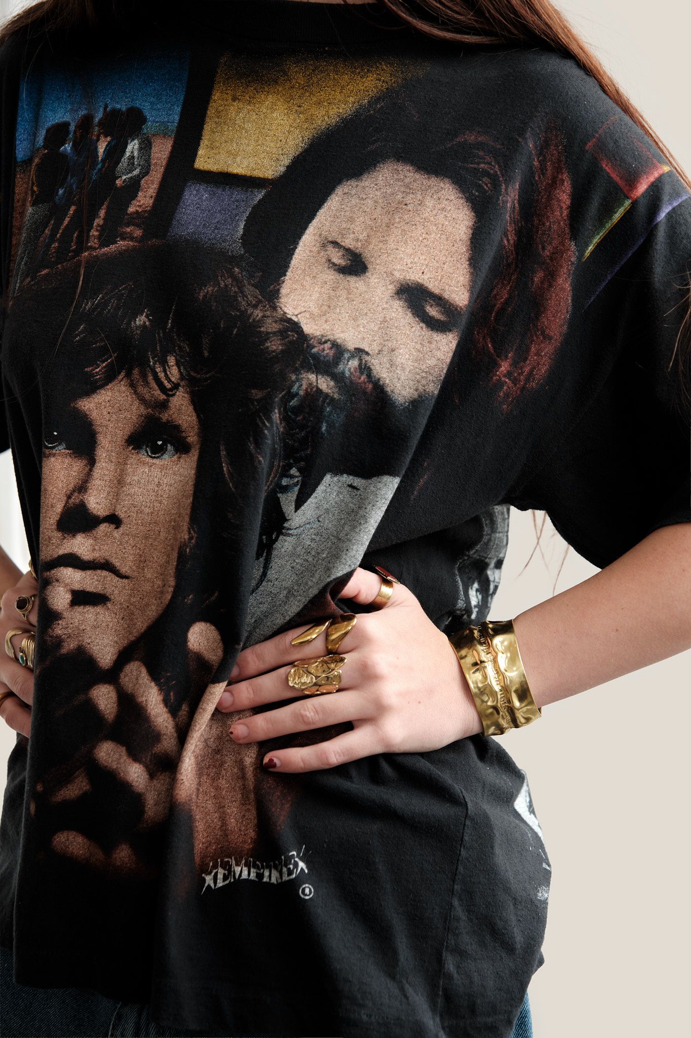 Black t-shirt with vintage portrait graphics and gold bracelets.