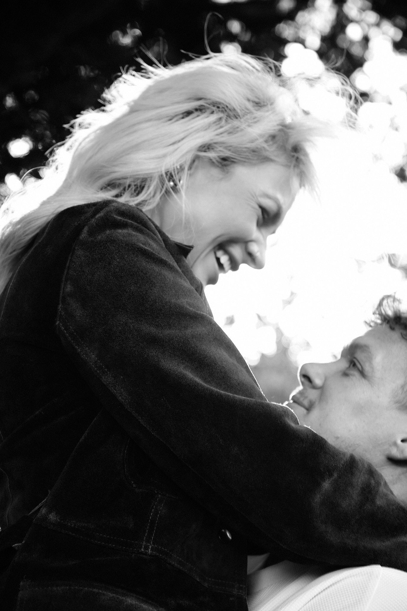 Black and white portrait of couple sharing tender moment in natural lighting.