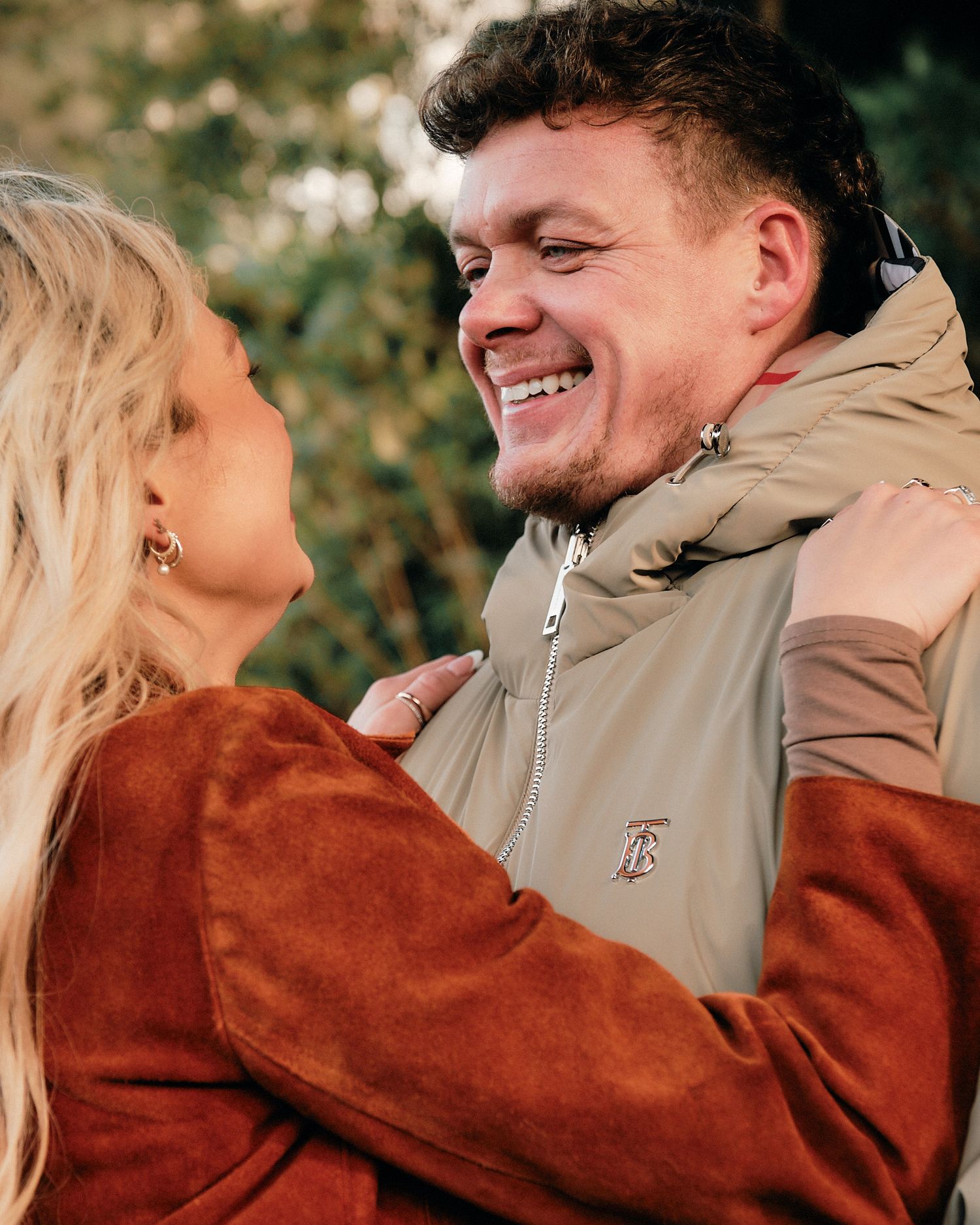 A couple shares playful and loving moments together against a natural backdrop.