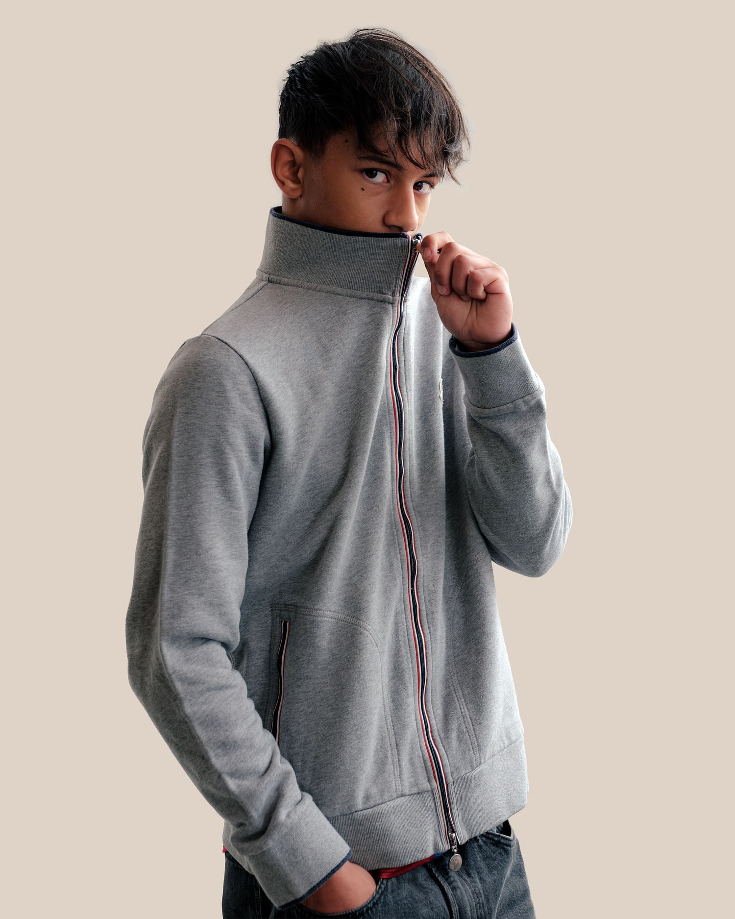 Back view detail of grey athletic jacket with zipper closure.