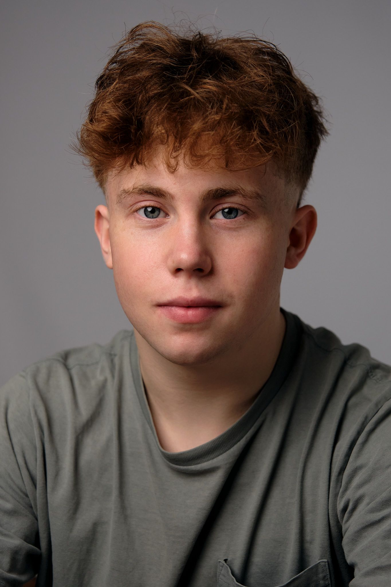 A series of four headshots showing different angles and expressions of a young person with curly hair in a gray shirt.