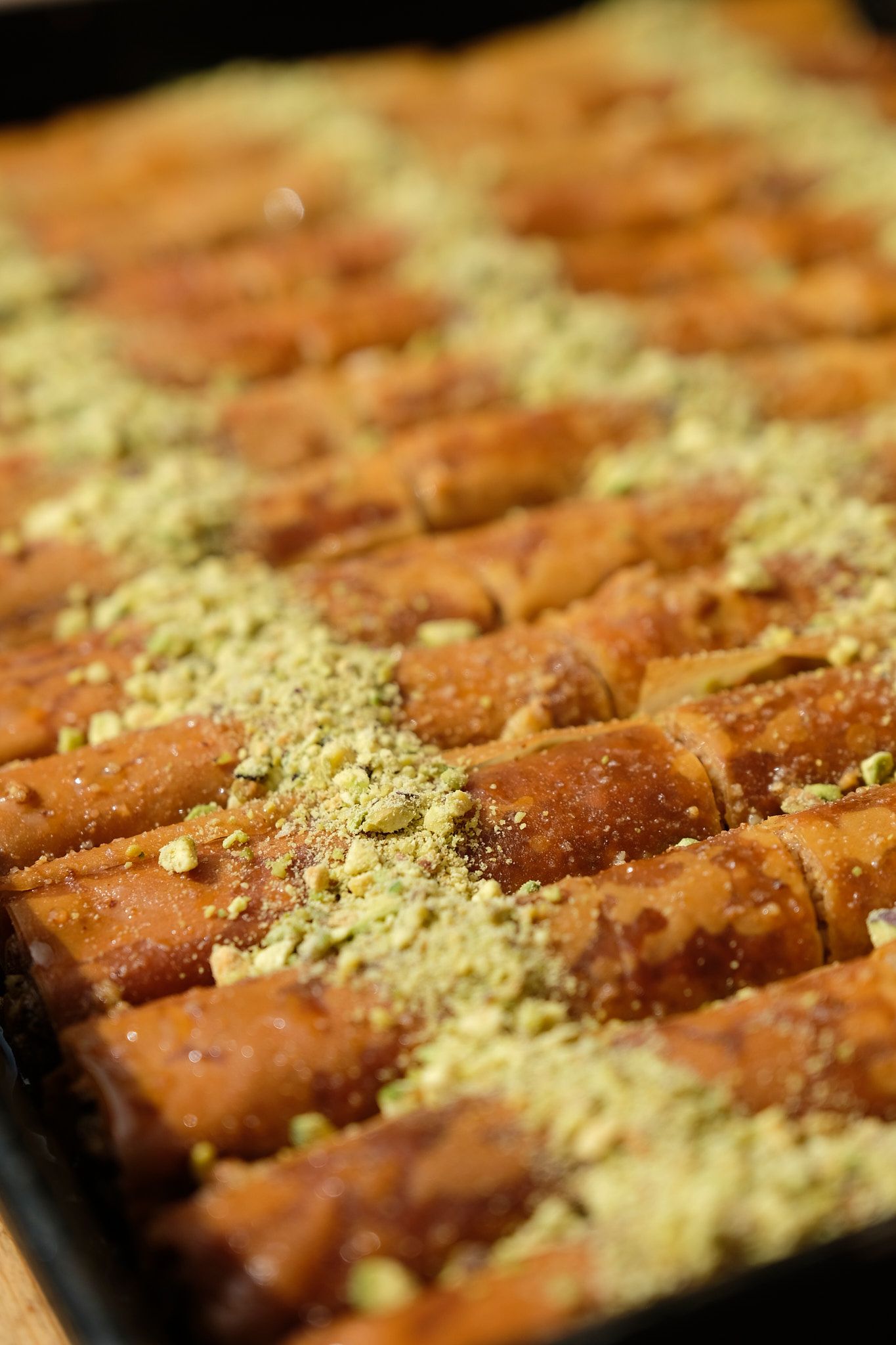 Macro shot of brownish-red tiles dusted with golden crumbs in diagonal pattern.