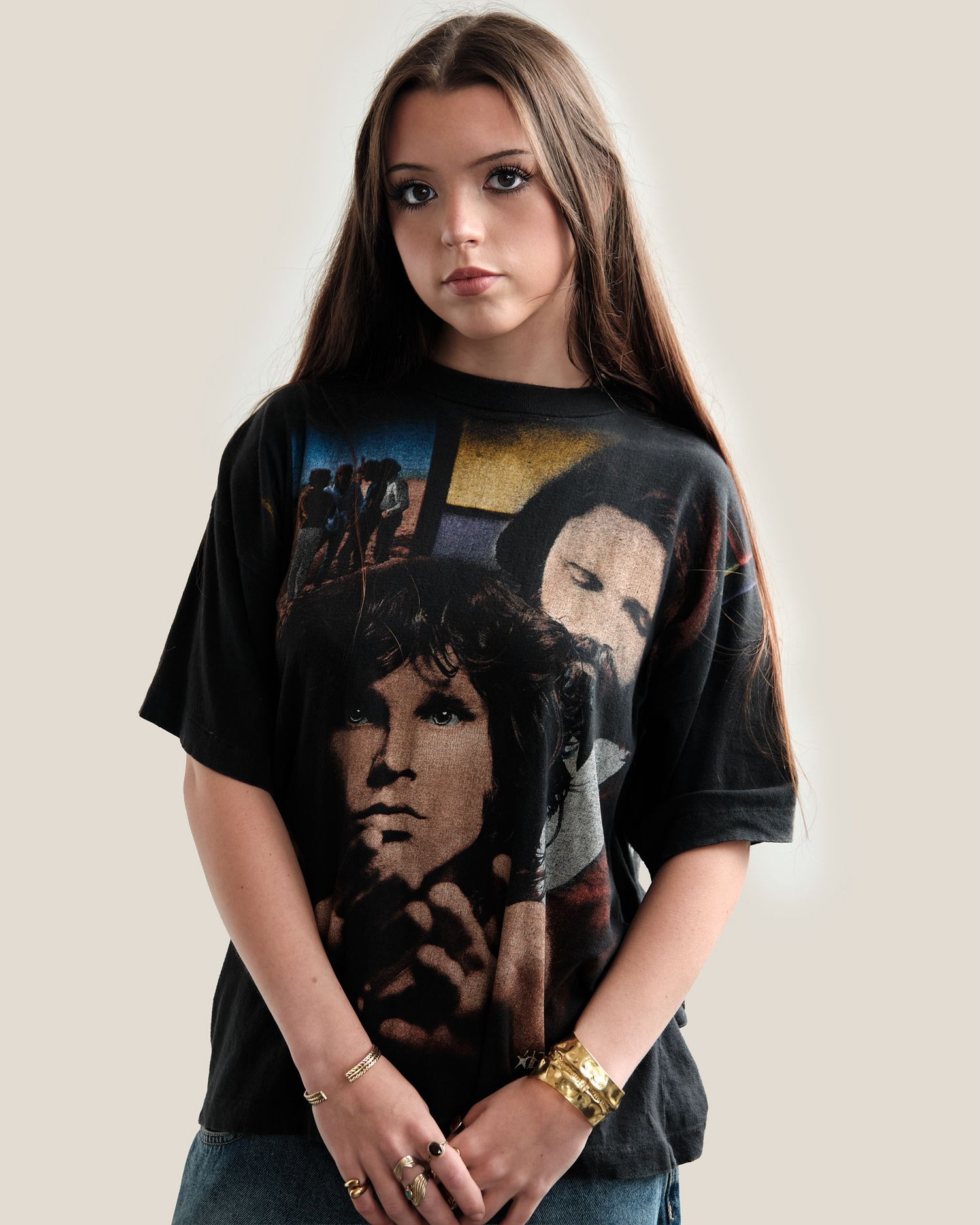Person wearing black graphic t-shirt with vintage rock band design against white background.