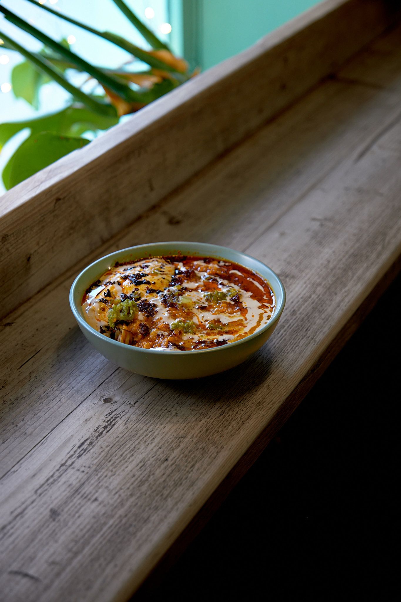 Middle Eastern dip with garnishes photographed on rustic wooden surface in natural light.