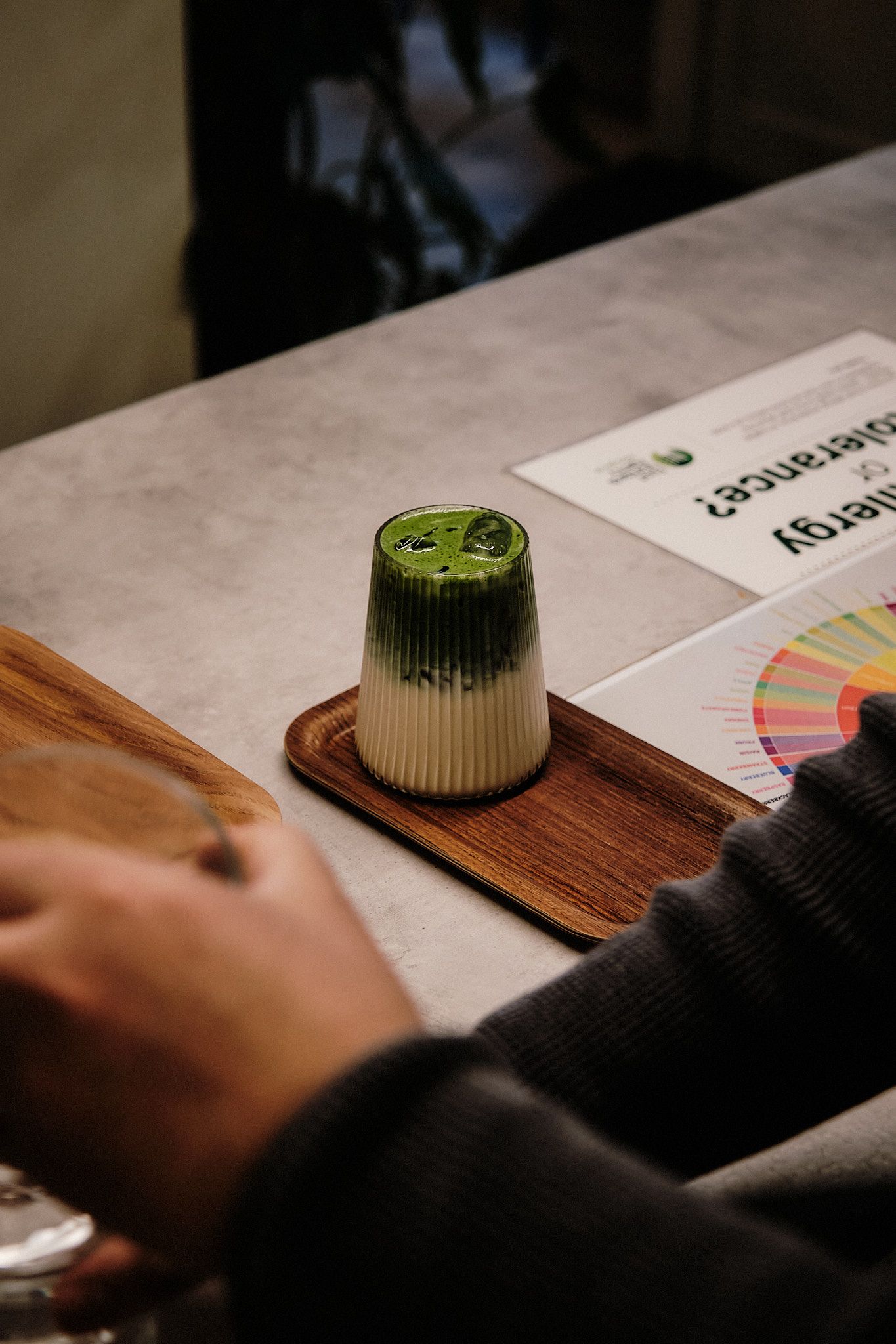A matcha green tea preparation setup with a color reference chart on a wooden board.