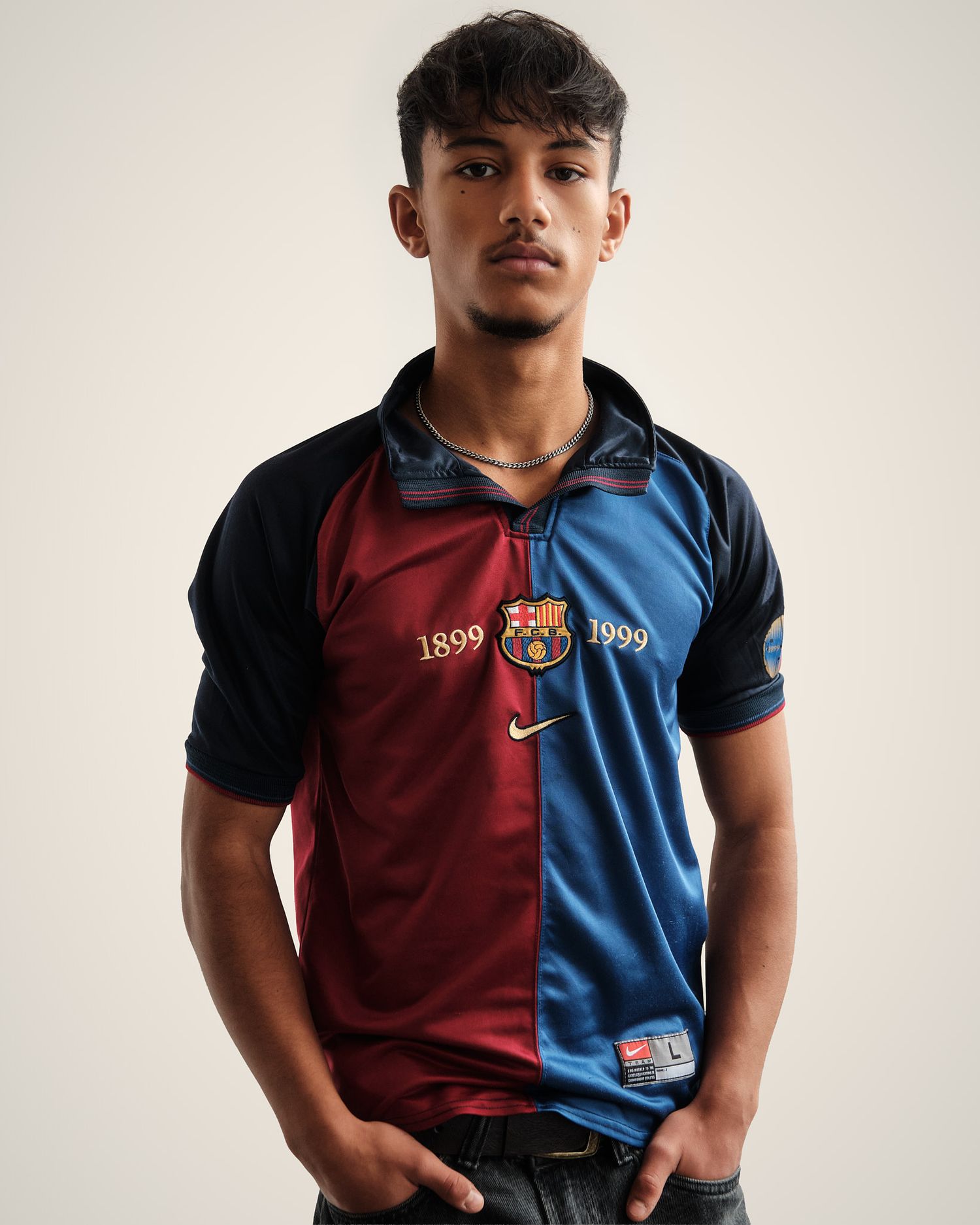 Athletic model wearing vintage Barcelona FC jersey in red and blue halves against white background.