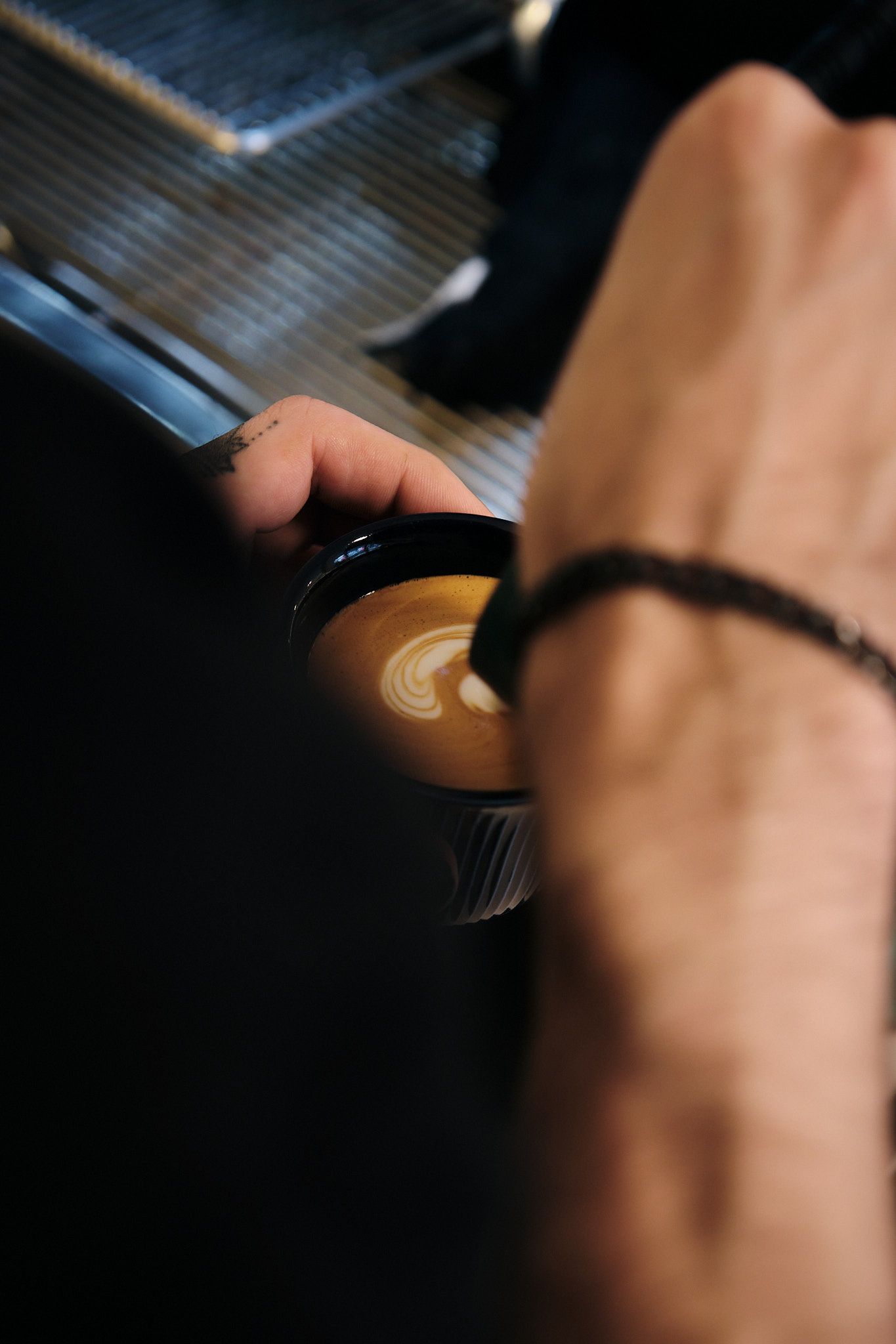 Close-up shot of latte art being created with steamed milk.