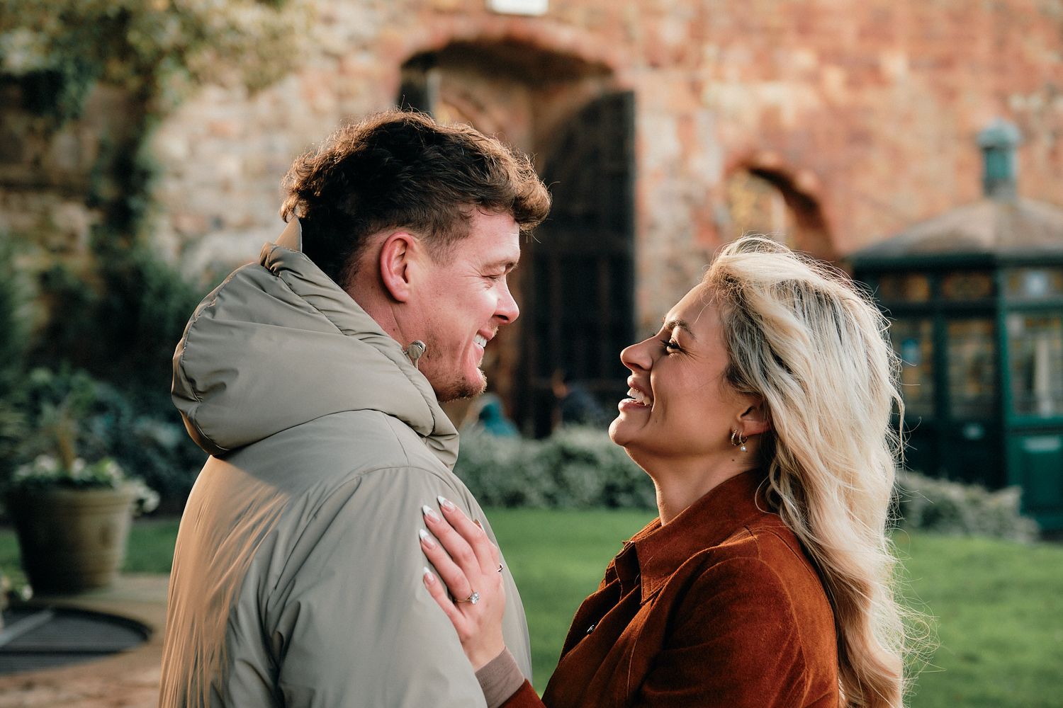 Romantic sequence of a couple embracing near a rustic brick wall outdoors.