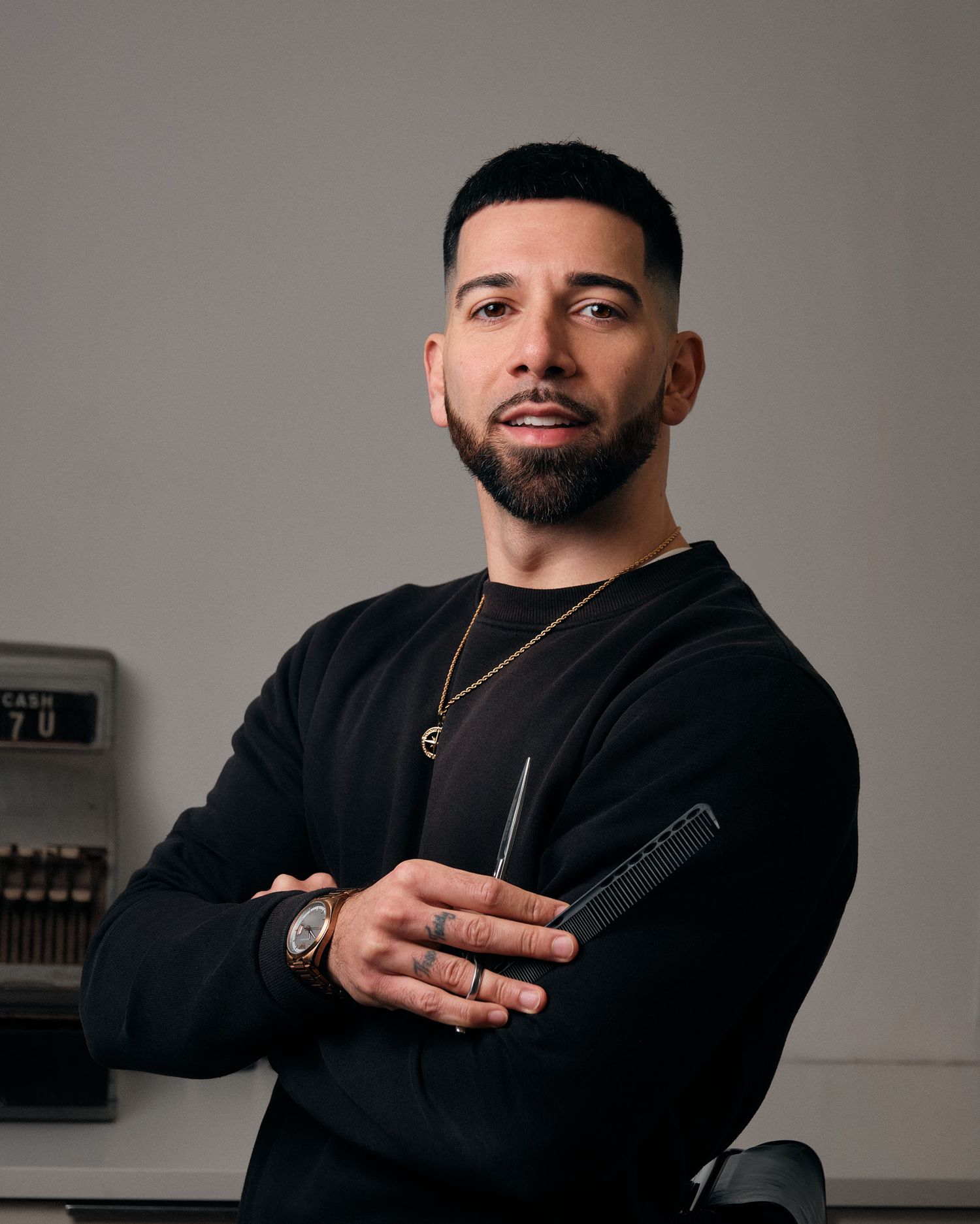 Professional studio portraits show someone in a black sweater posing against a gray background from different angles.