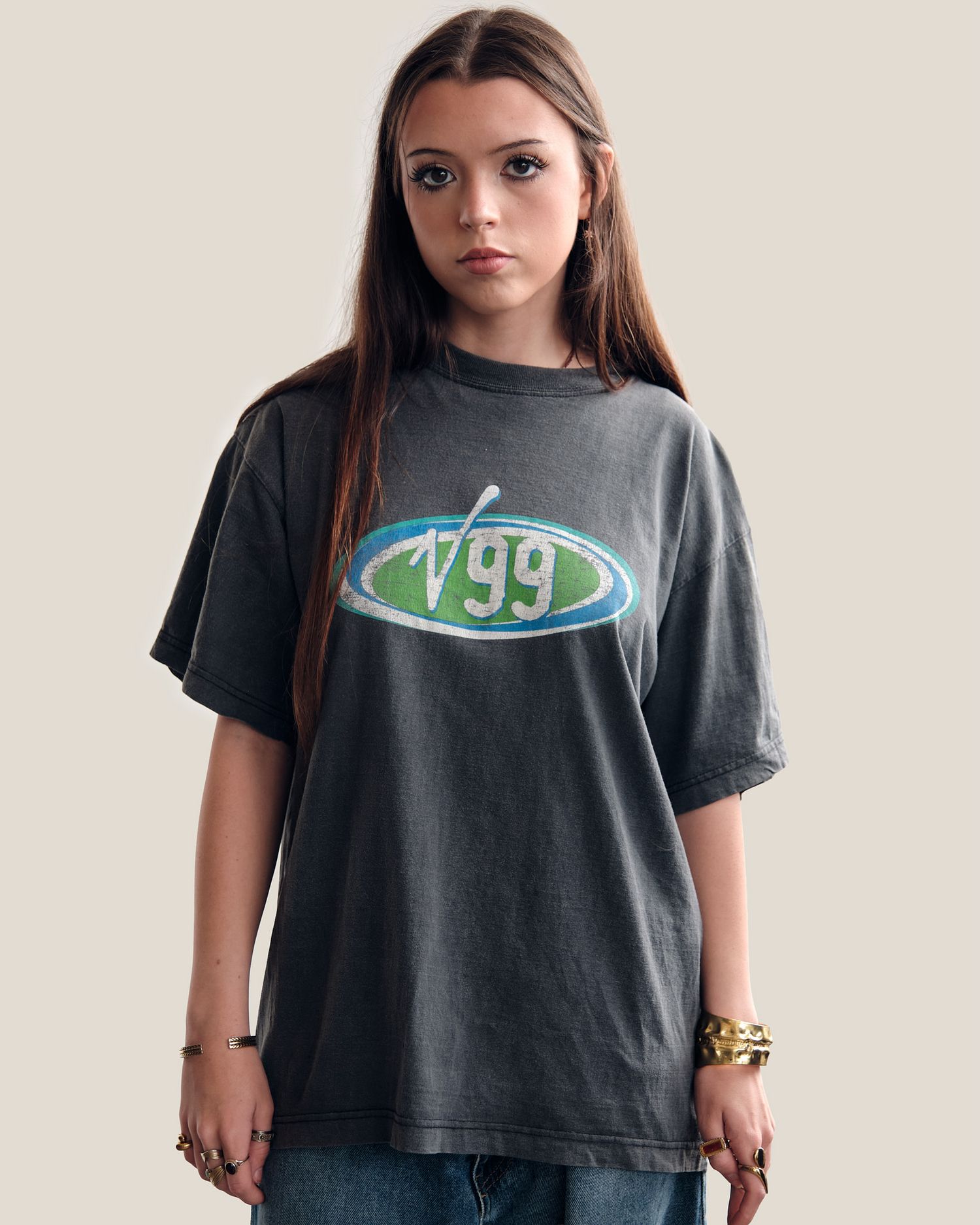 Person wearing a black t-shirt with green logo against light background.