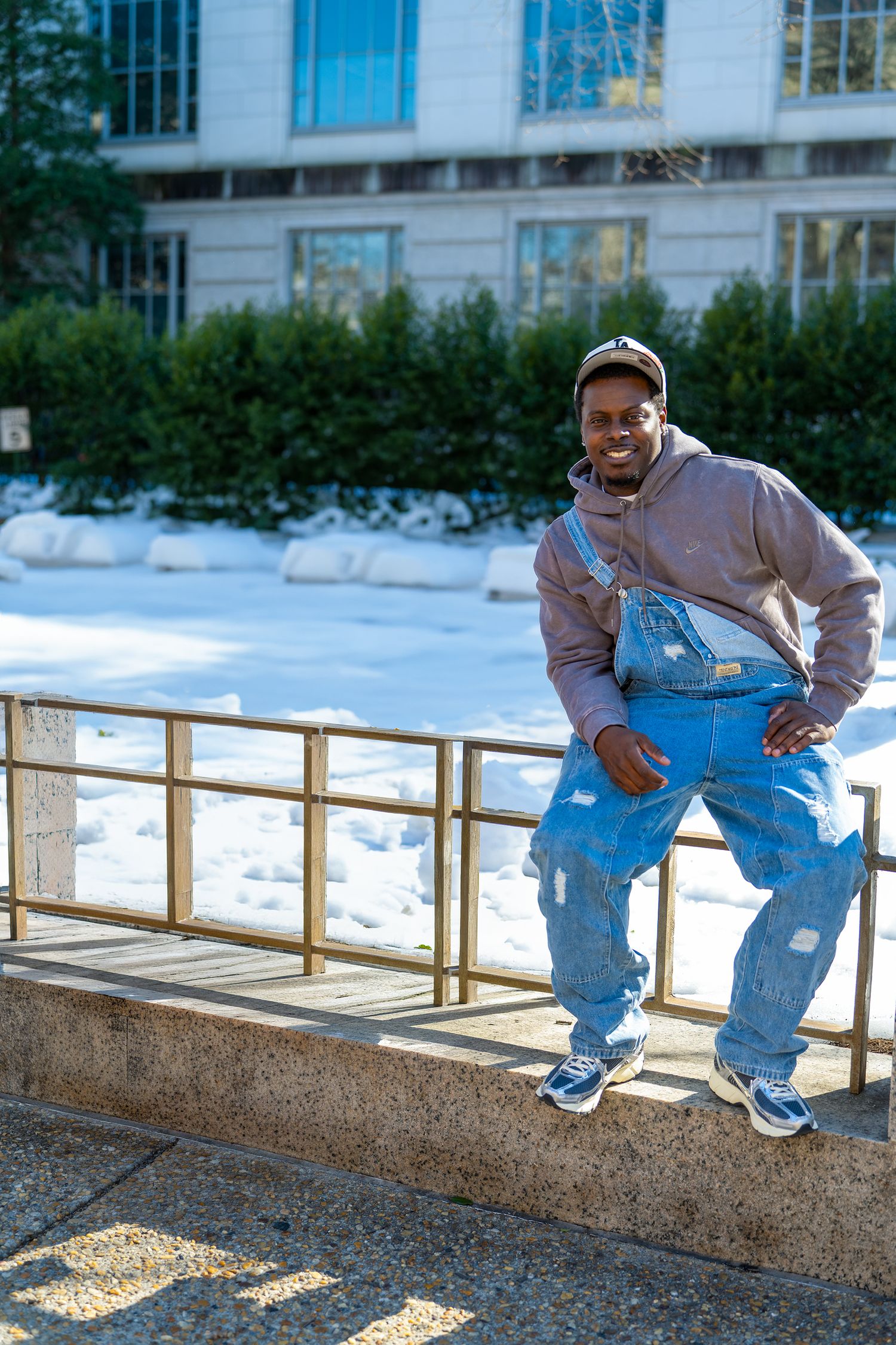 Sequence showing person in blue jeans performing parkour moves on a snowy ledge.
