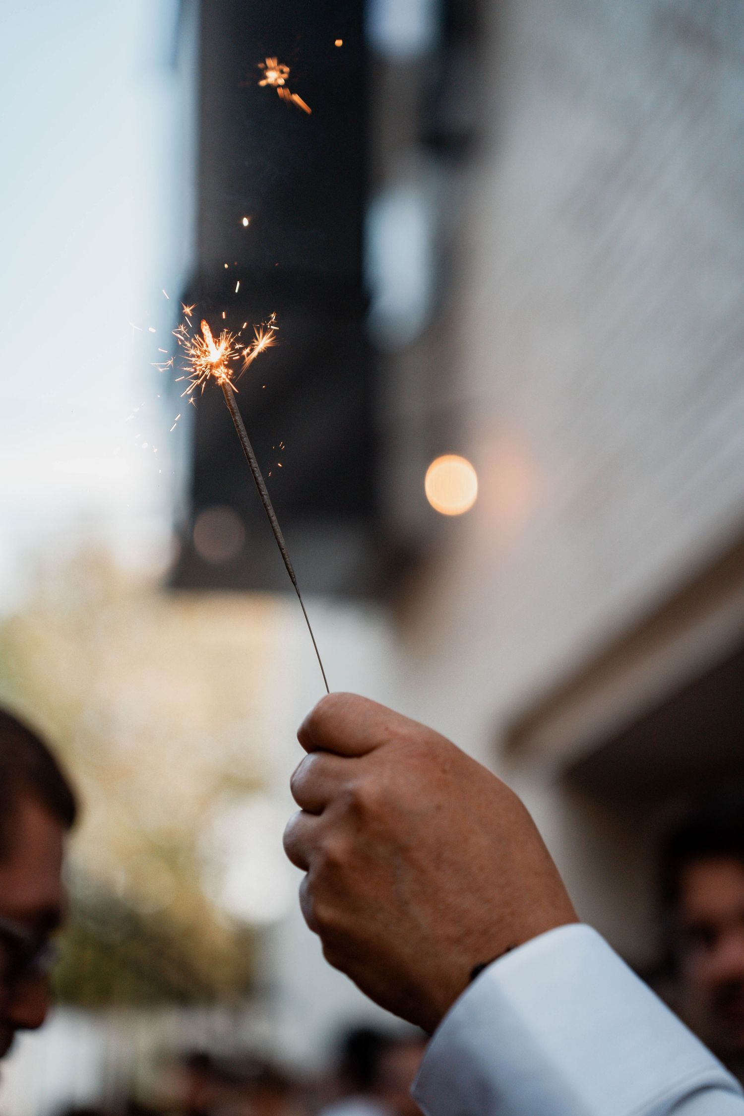 Wedding sparklers creating magical light trails against dark background during celebration.