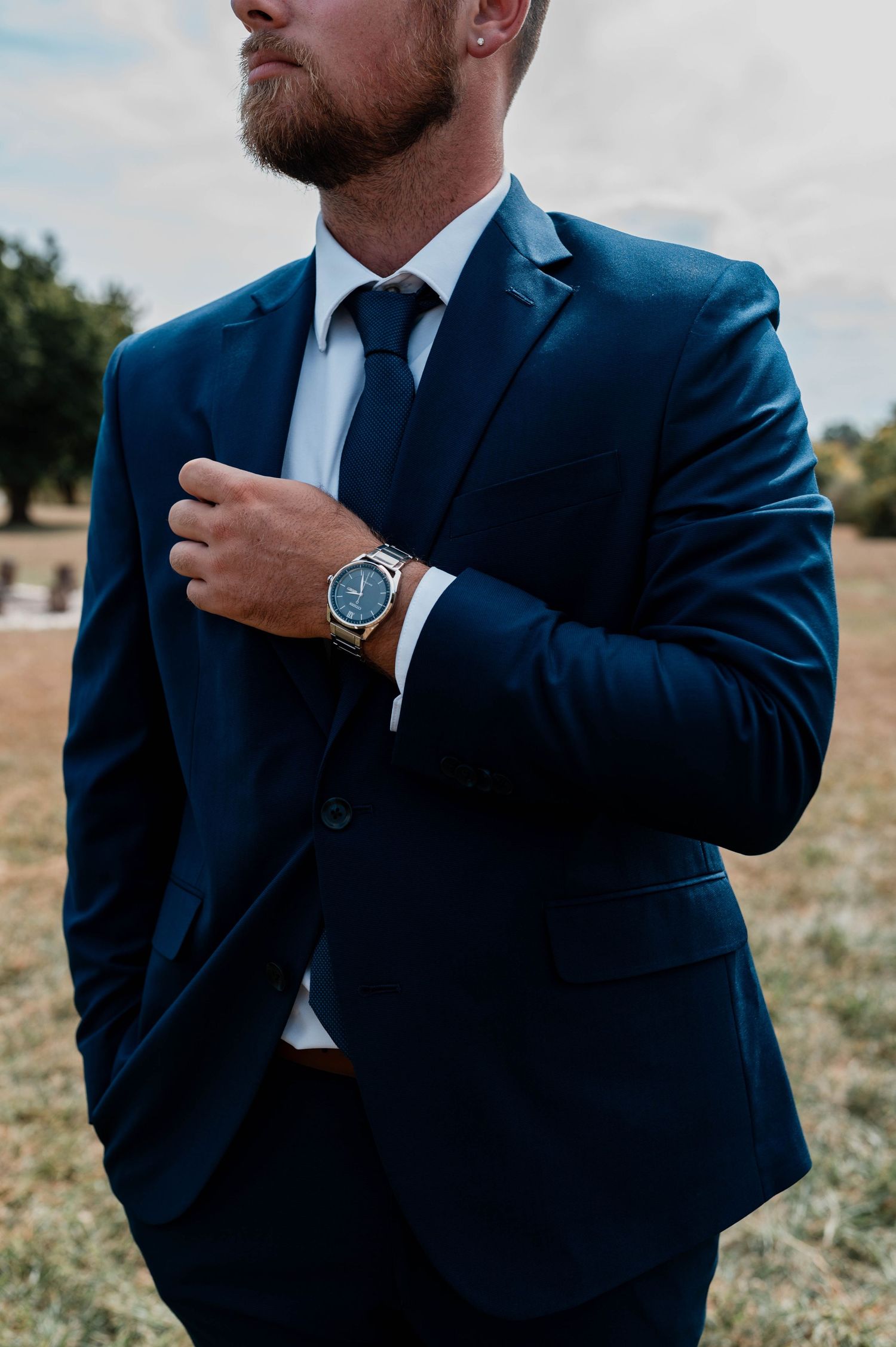 Close-up details of navy suits and watches worn by groom.