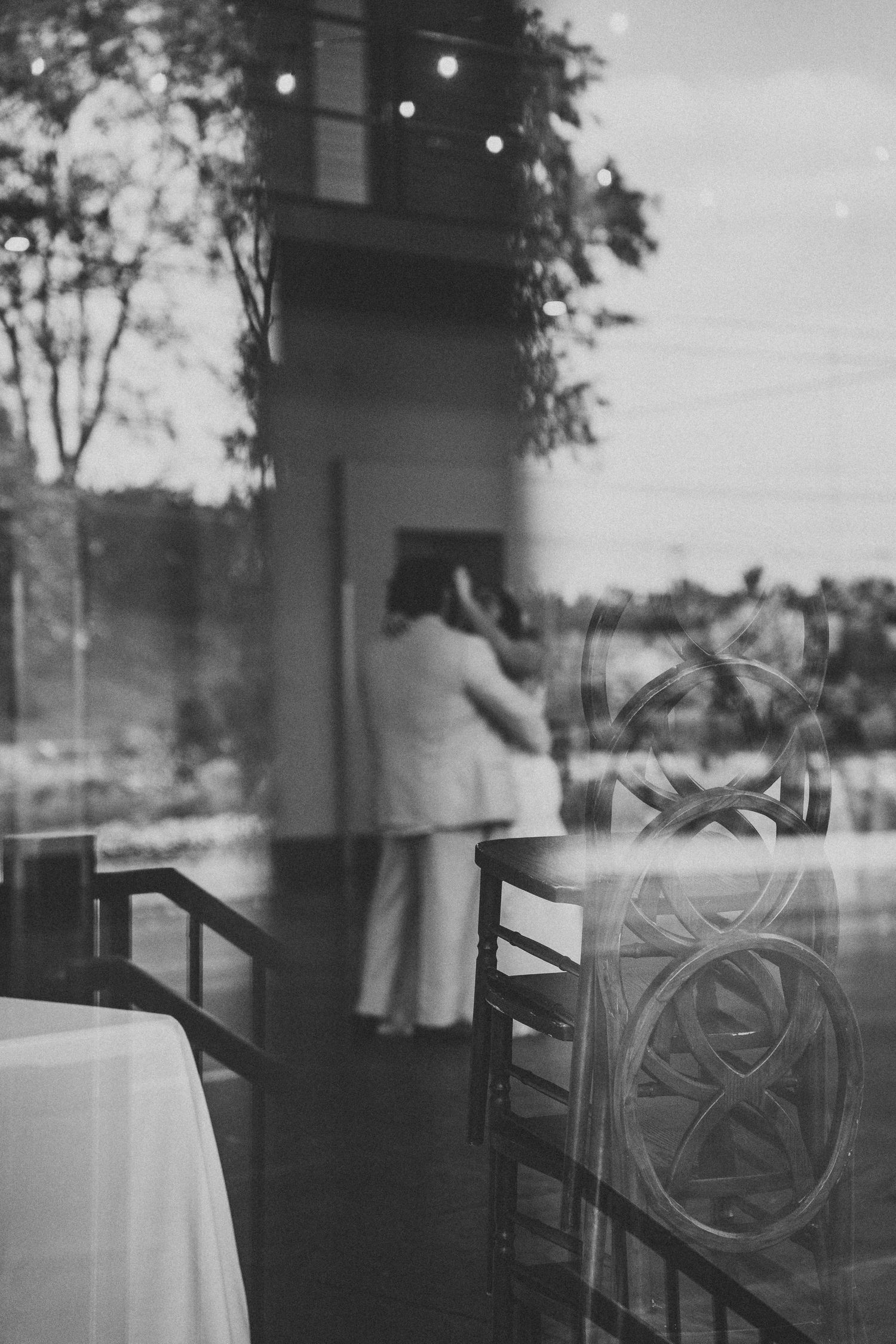 Moody black and white window reflections with string lights visible.