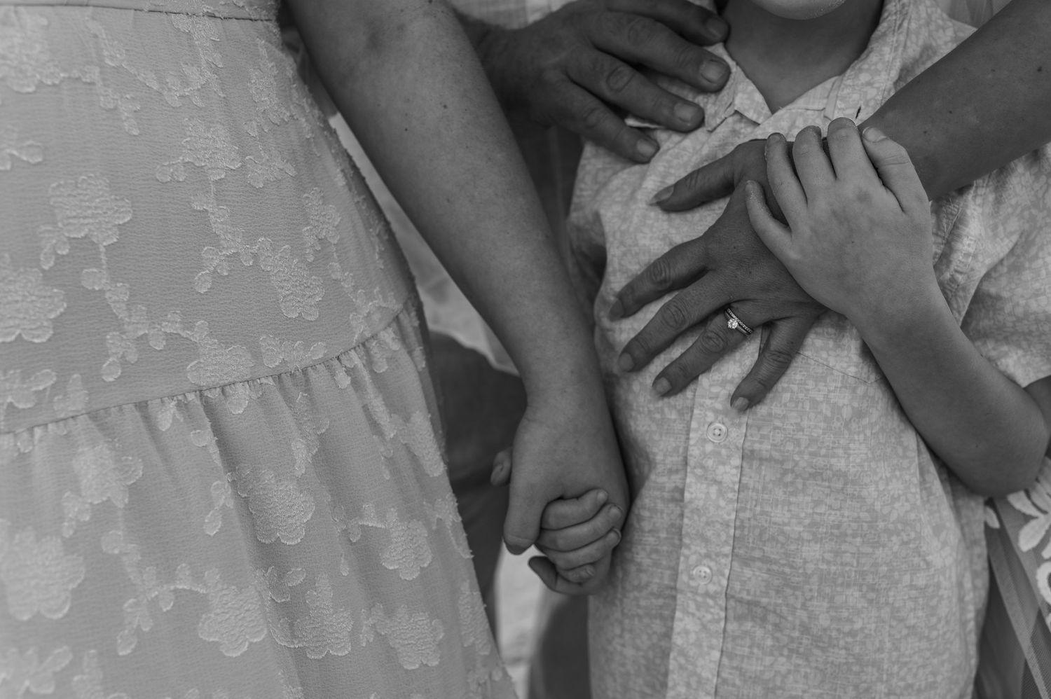 Black and white close-up of hands with delicate lace details.