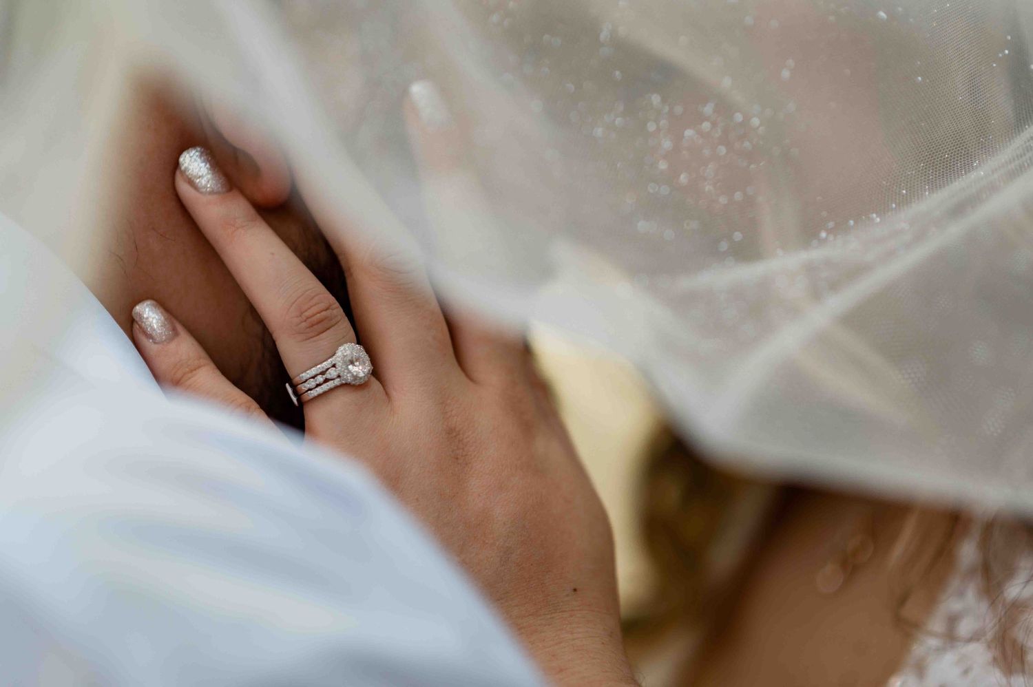 Close up detail of delicate lace and sparkly details on white fabric.