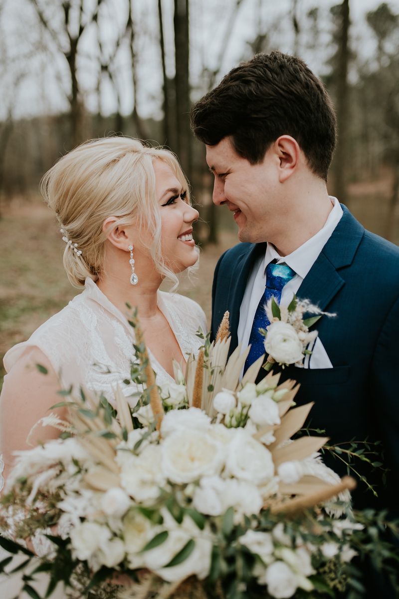a couple kiss at Hoyt Hallow wedding venue in Alabama with a white bouquet