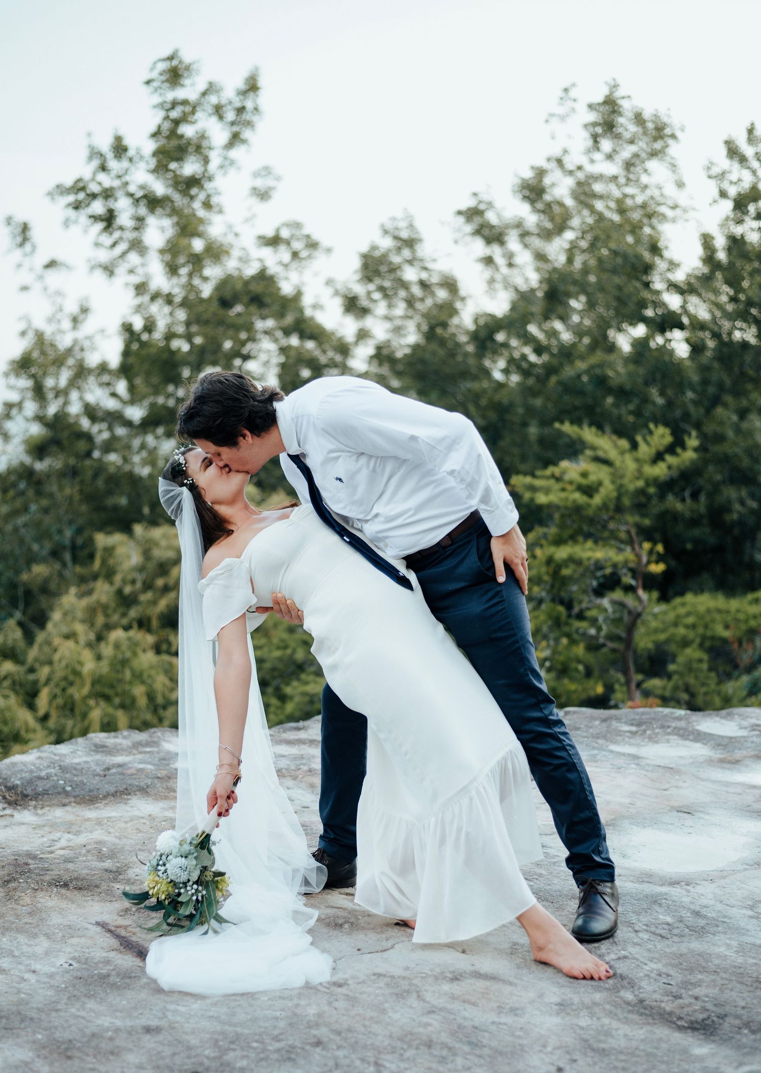 a couple atop a Alabama mountain as they kiss on their wedding day