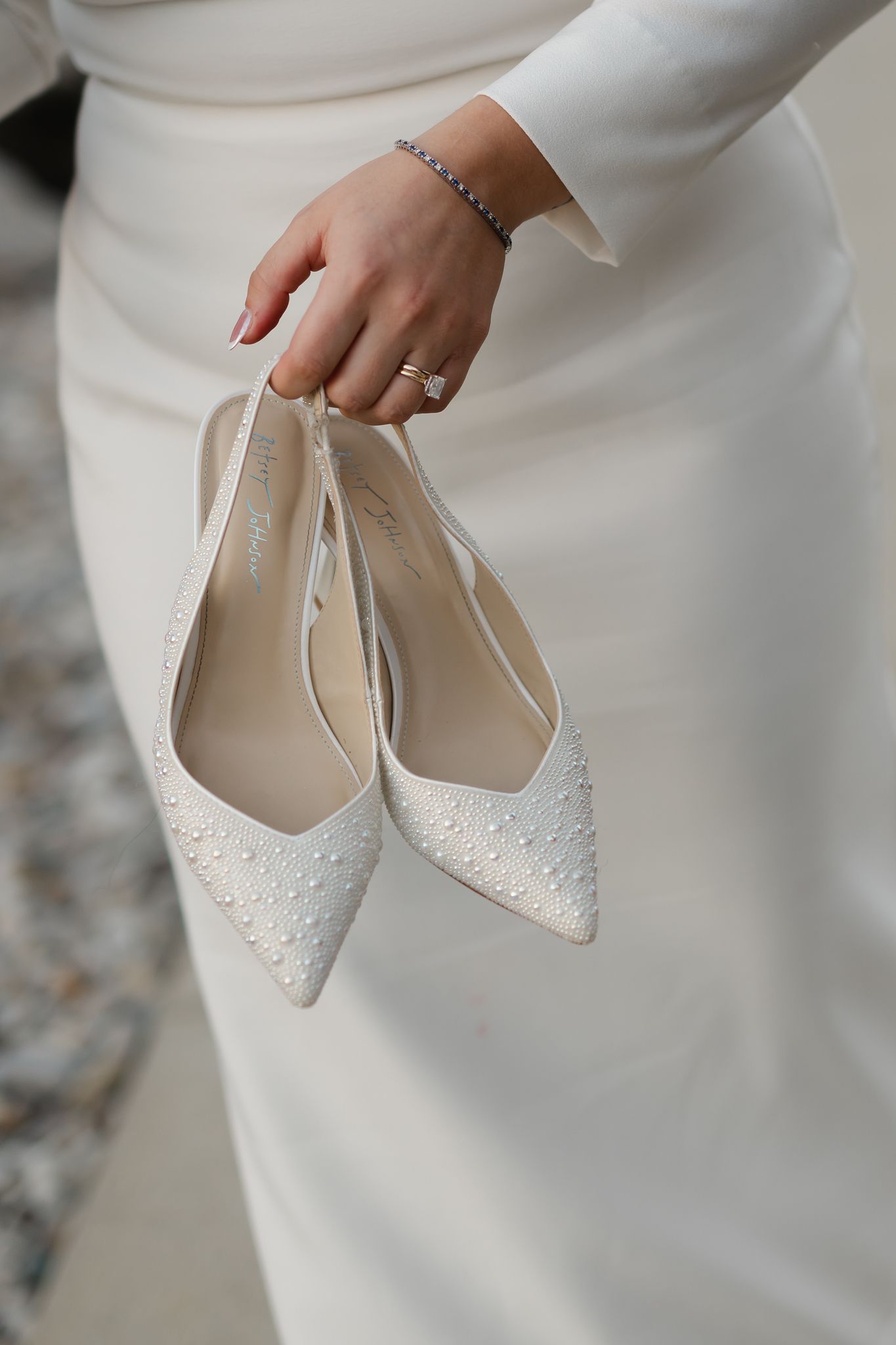 a bride holds her beautiful white shoes as she dances barefoot on her Alabama wedding day will Holli Hobbs photography
