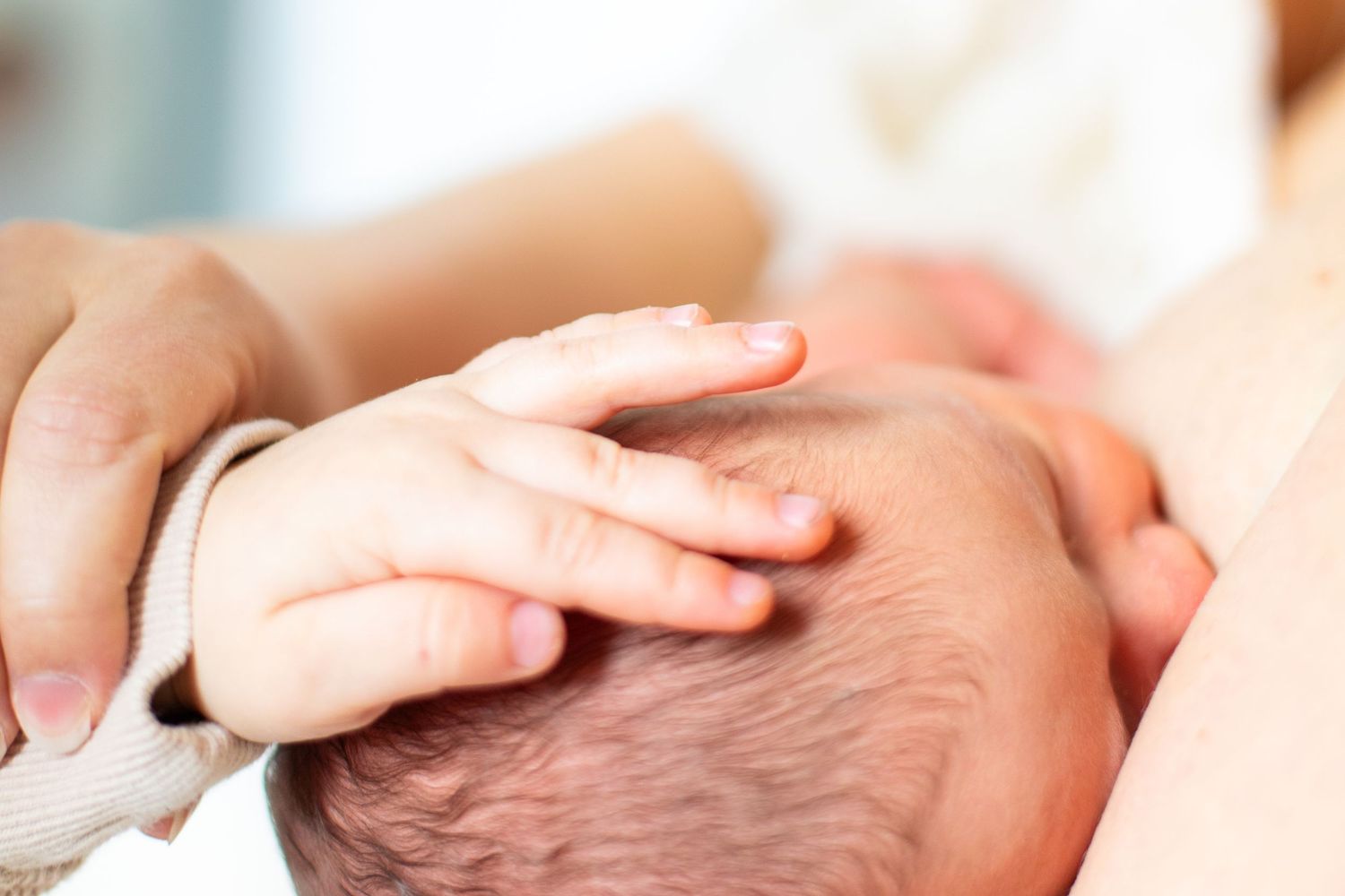 Isoveli silittää vastasyntynyttä vauvaa newborn-kuvauksessa studiossa Vantaalla.