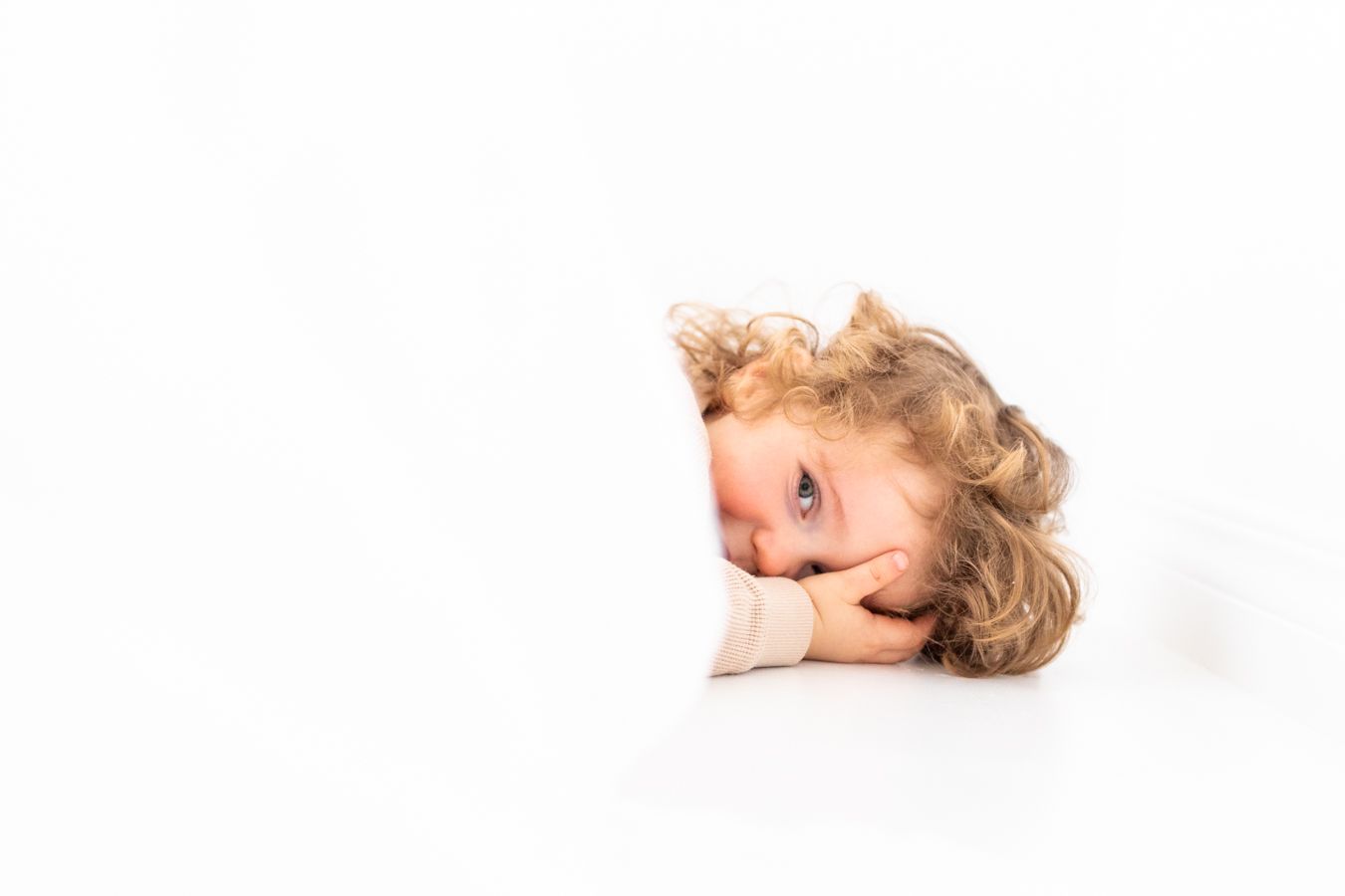 Lapsi hassuttelee pikkusisaruksensa newborn-kuvauksessa studiossa Vantaalla.