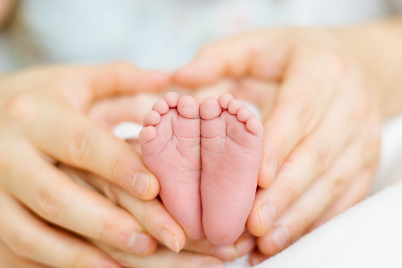 Vastasyntyneen pikkuruiset varpaat vanhempien käsissä newborn-kotikuvauksessa. Newborn-lifestylekuvaus Lohjalla, Espoossa ja Uudellamaalla.