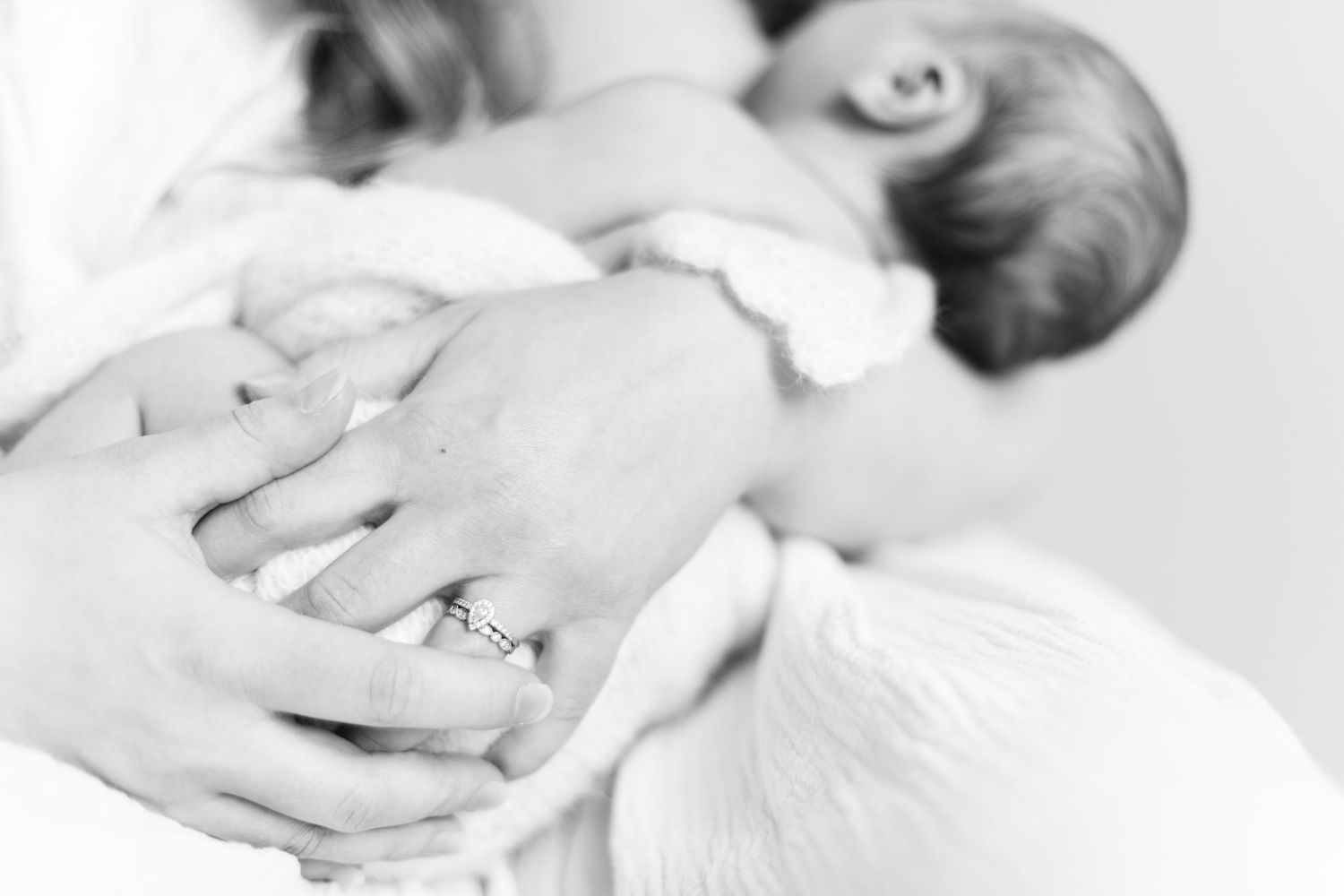 Äiti pitelee vastasyntynyttä vauvaa newborn-kuvauksessa studiossa Vantaalla.