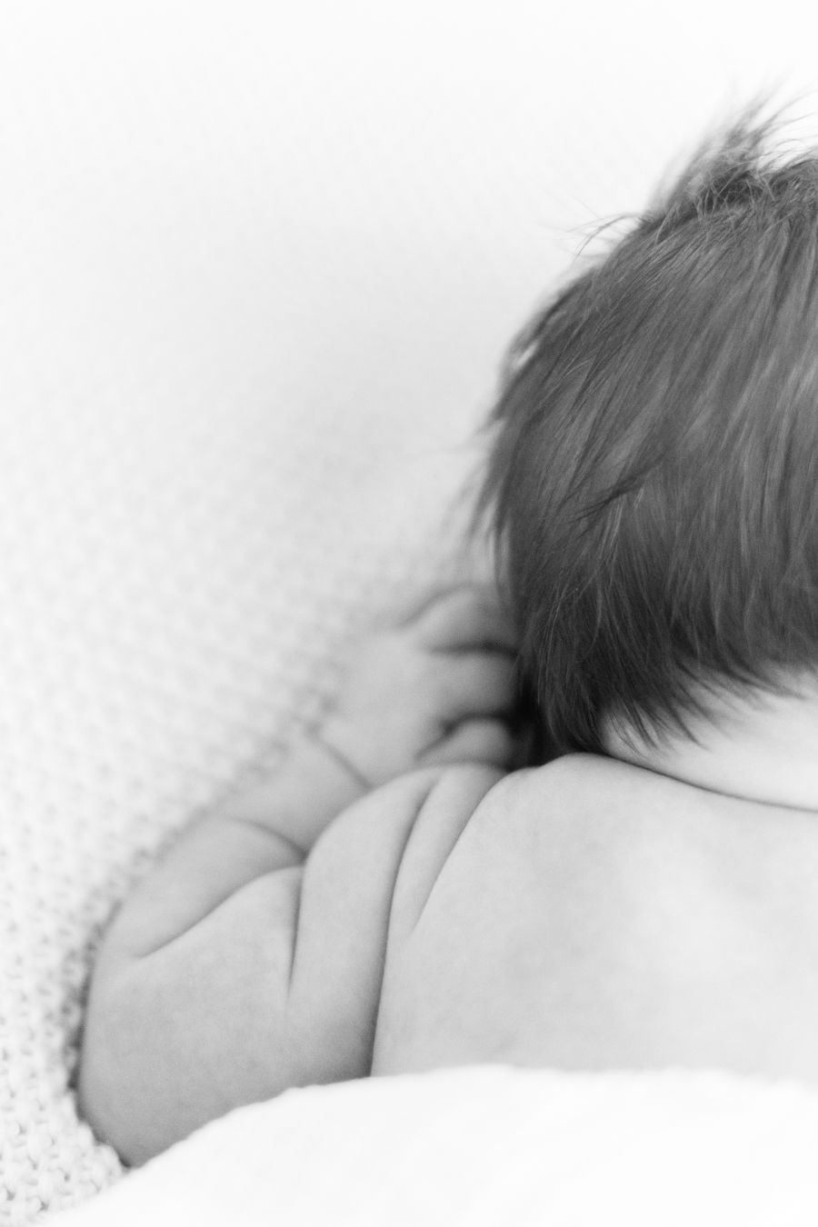 Vastasyntyneen vauvan varpaat pilkistävät peiton alta newborn-kotikuvauksessa. Newborn-kuvaus Lohjalla ja muulla Uudellamaalla.