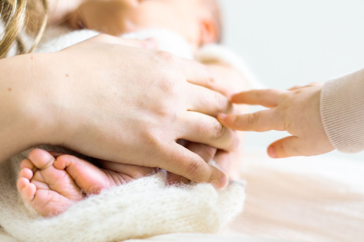 Vastasyntynyt vauva yhdessä koko perheensä kanssa newborn-studiokuvauksessa Vantaalla.
